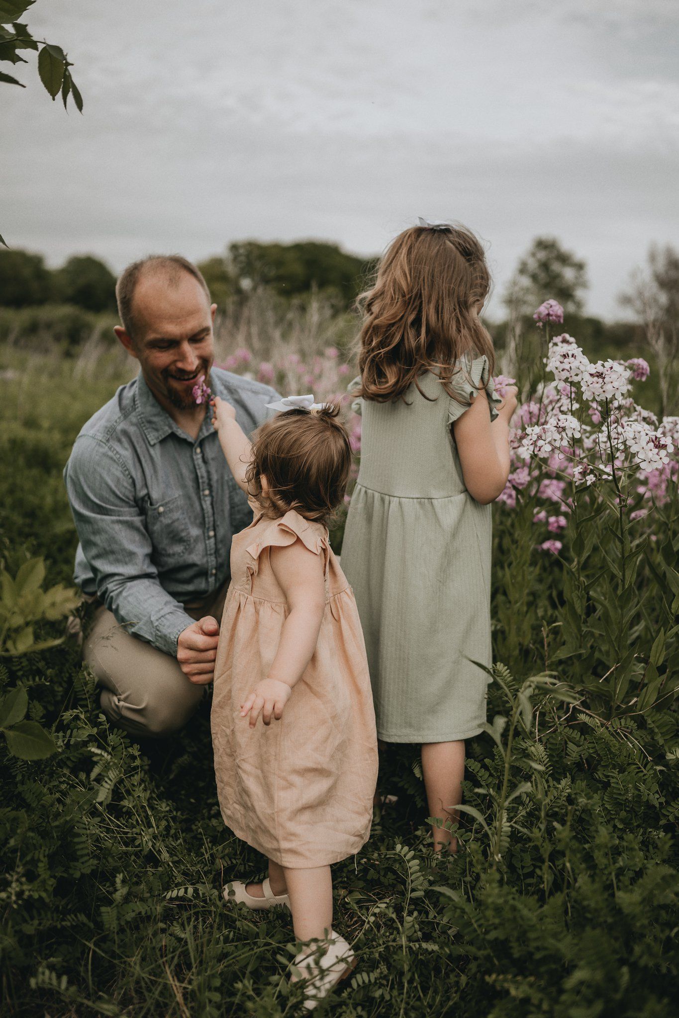 A sweet family moment among blooming flowers in a natural outdoor setting.