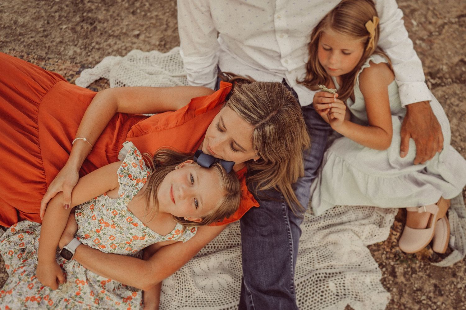 Intimate family moment captured on blanket during golden hour photoshoot.
