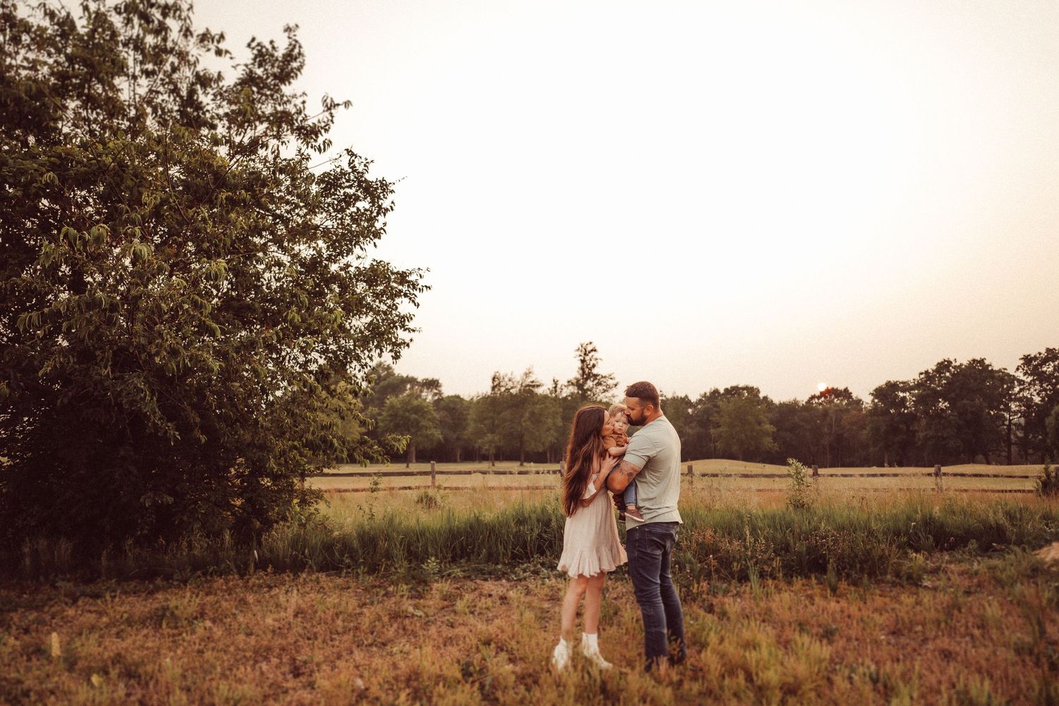 A romantic golden hour portrait in a serene countryside meadow.