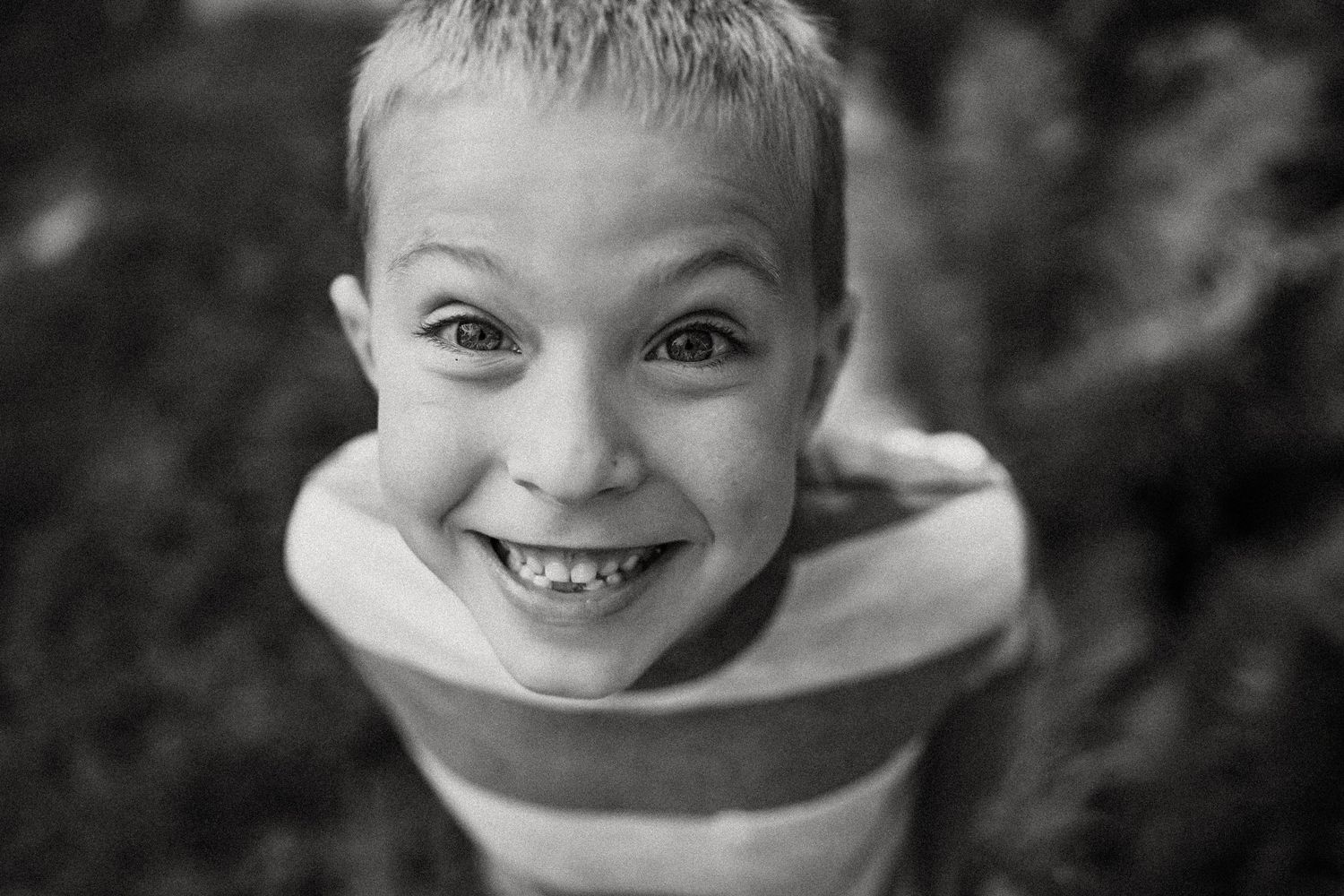 Close-up portrait in black and white showing a joyful expression and striped shirt.