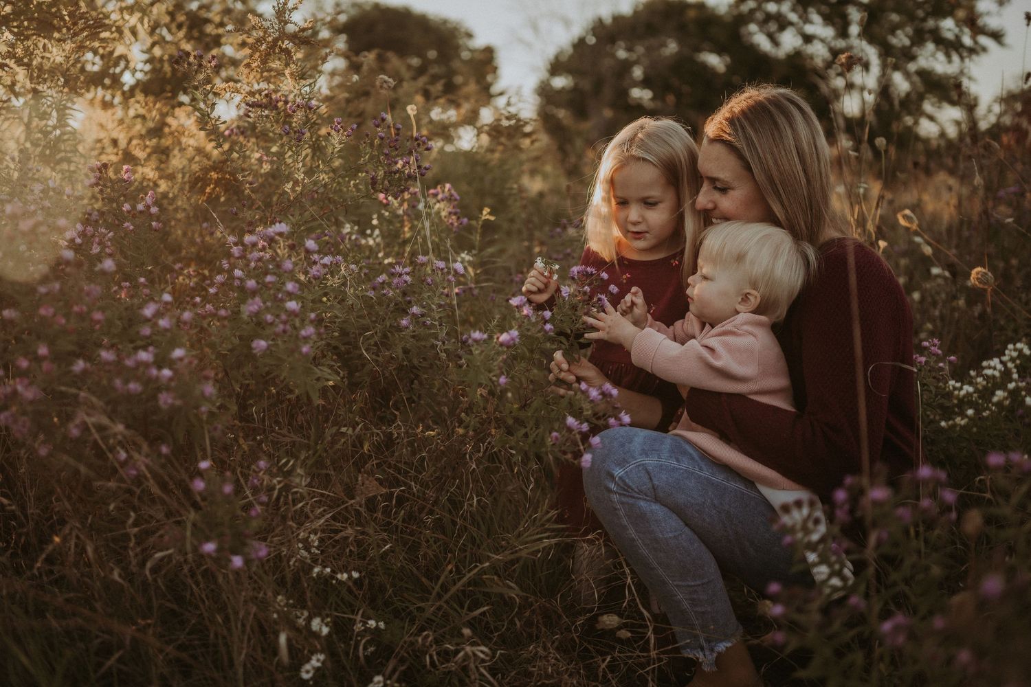 A tender family moment shared among wildflowers during sunset.