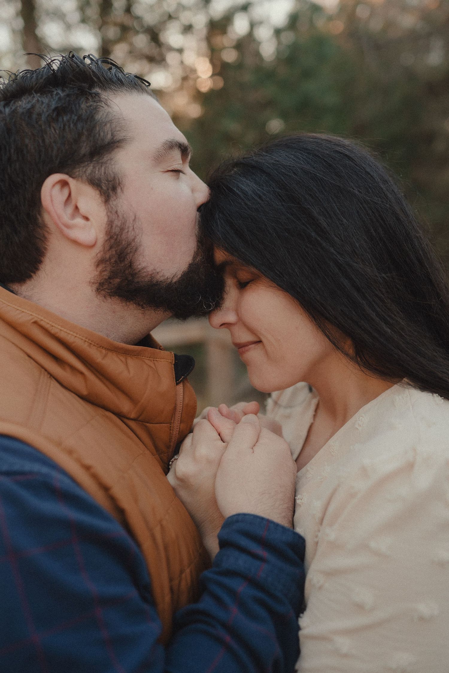 An intimate close-up moment captured in soft lighting with autumn foliage in the background.