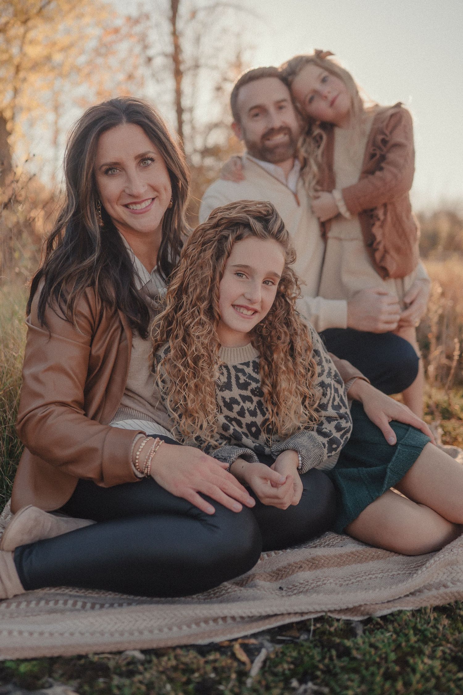 A candid series of outdoor family photos showing playful moments on a blanket during golden hour.