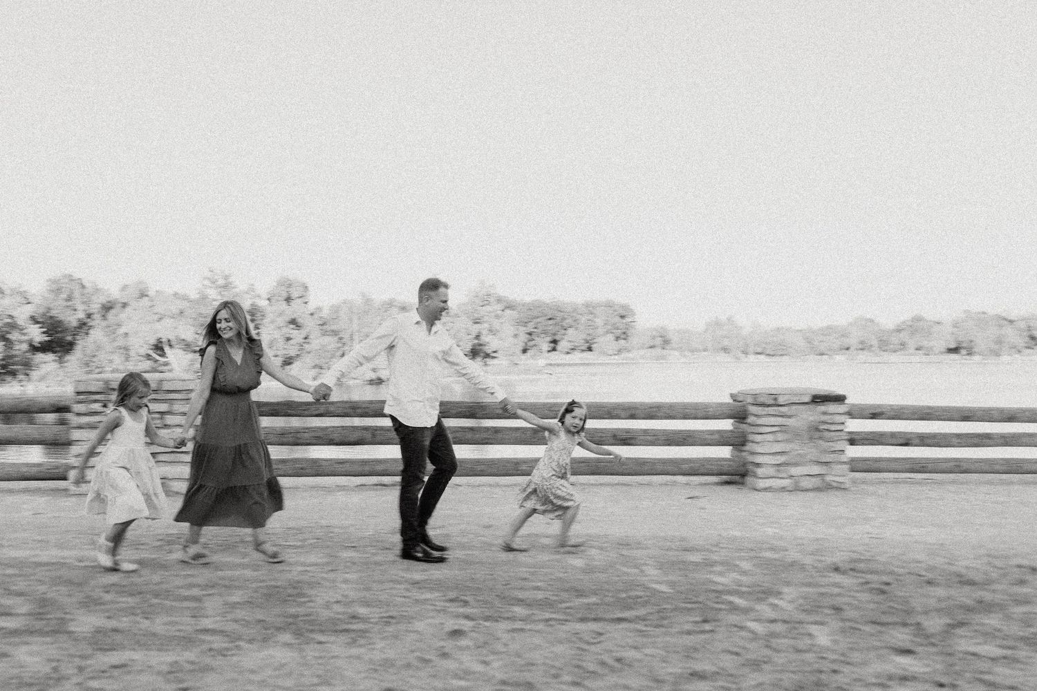 A joyful family moment captured in black and white as they run and play outdoors.