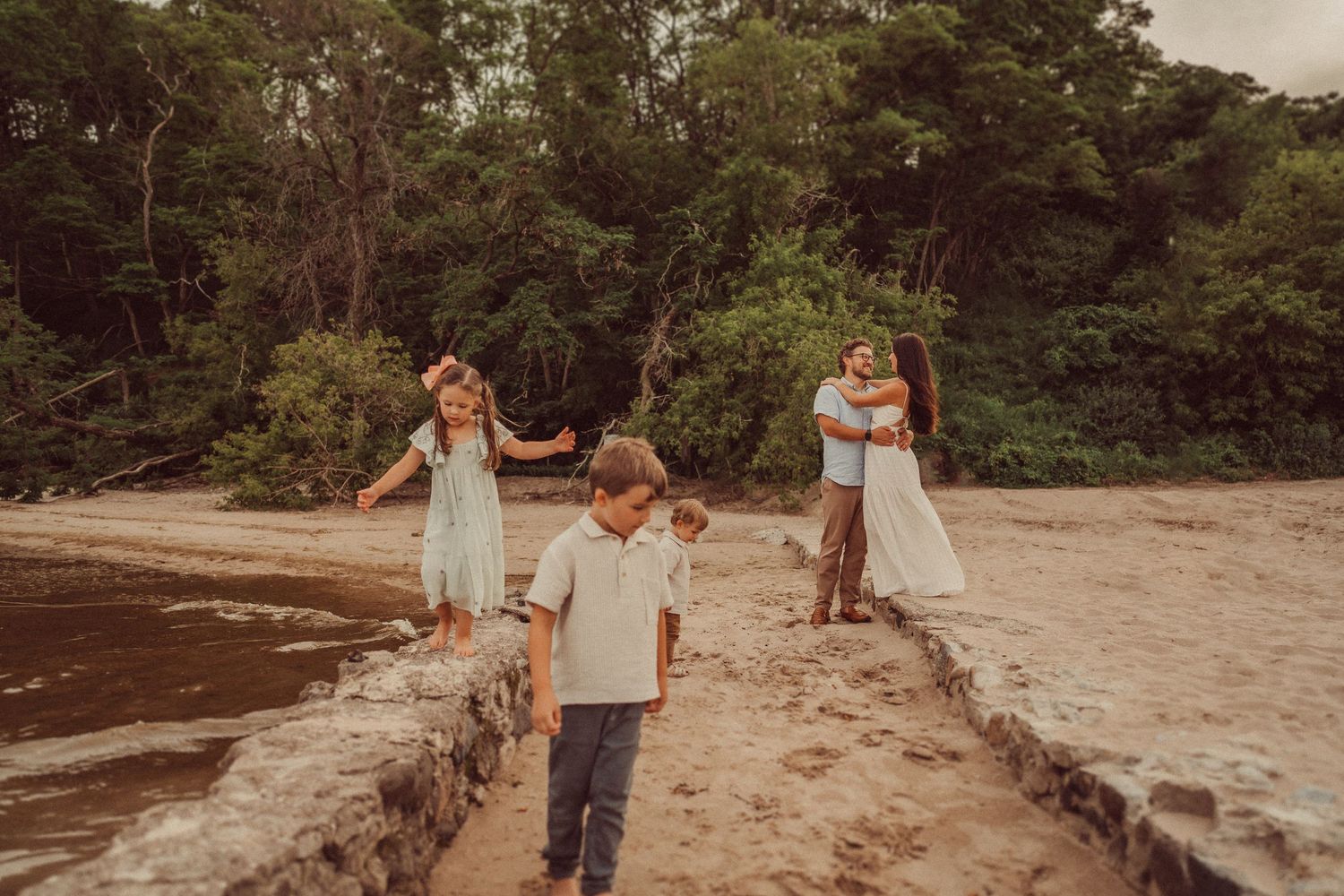 Family members walk together along a sandy beach path.