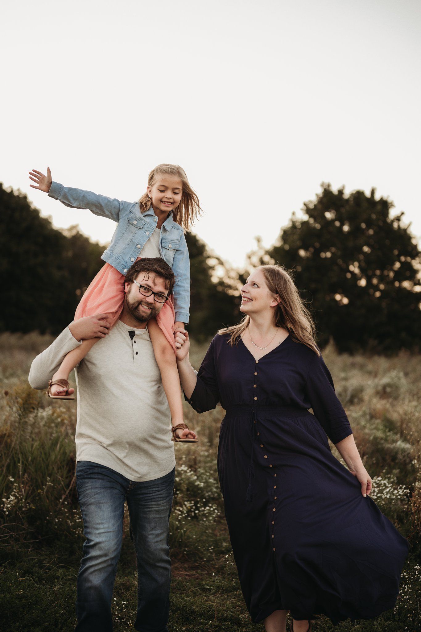A family enjoying a playful moment outdoors with someone giving a shoulder ride.