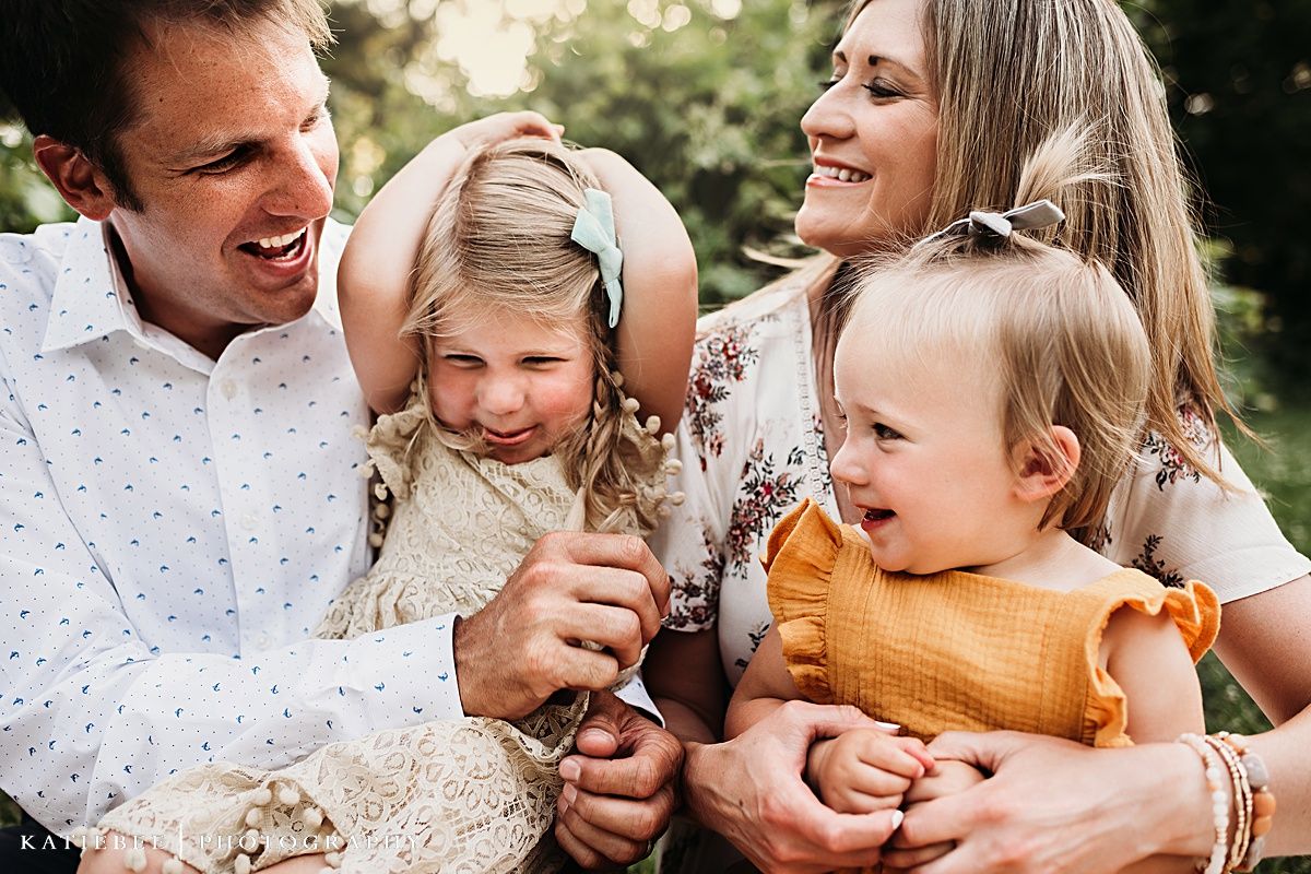 Candid family moment showing laughter and joy during outdoor photo session.