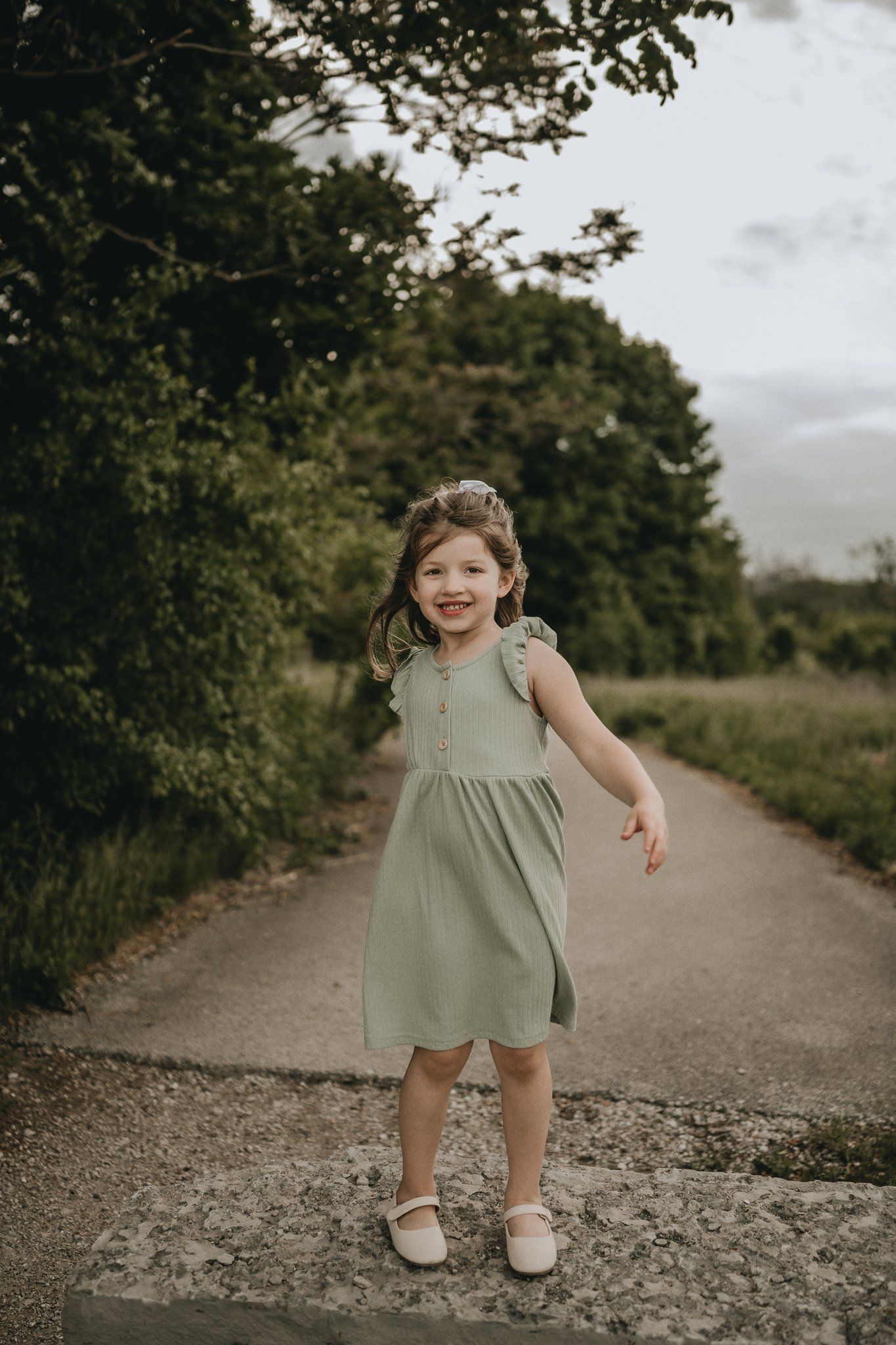 A playful moment captured on a tree-lined path showing movement and joy.