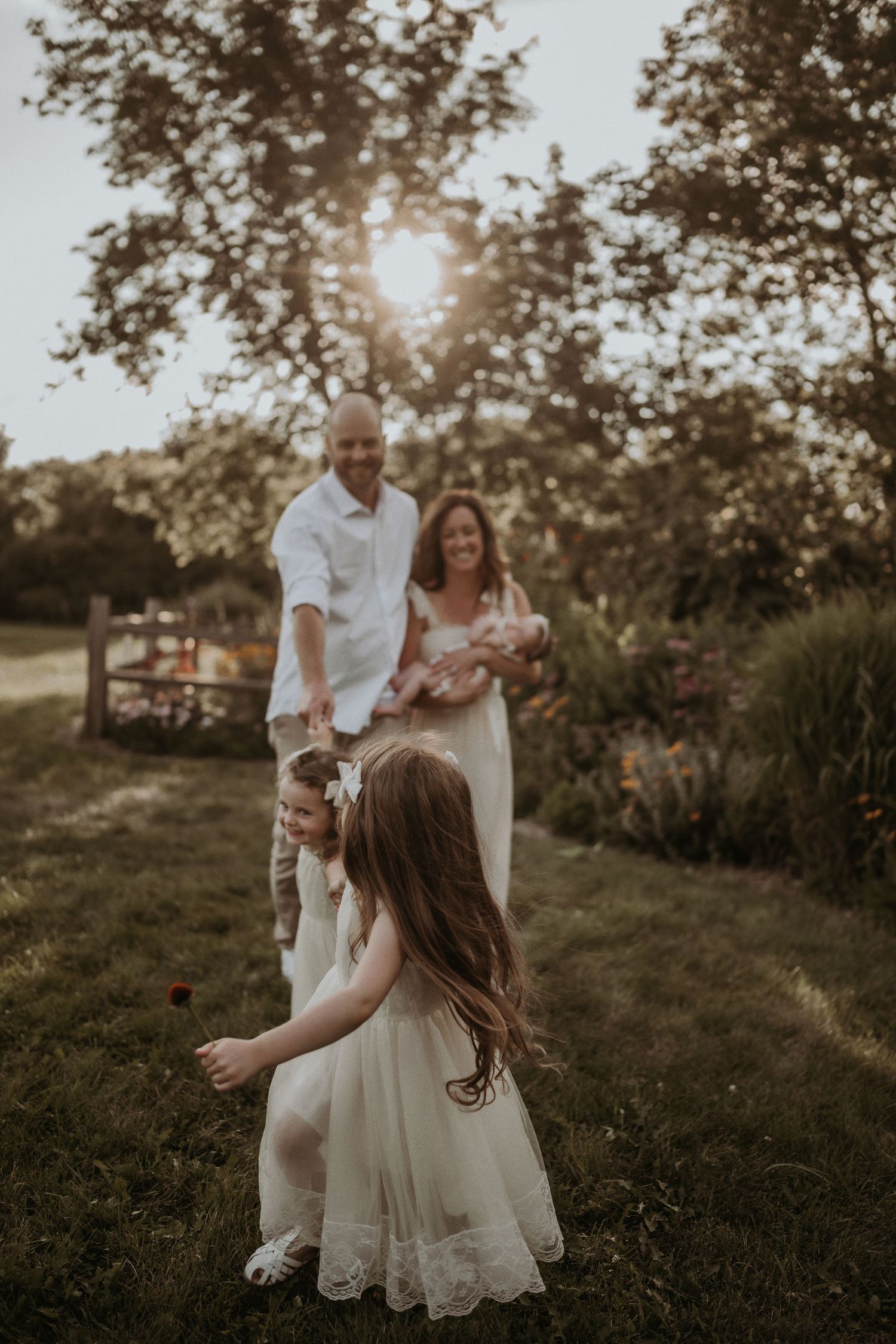 A candid family moment captured during golden hour in a lush garden setting.