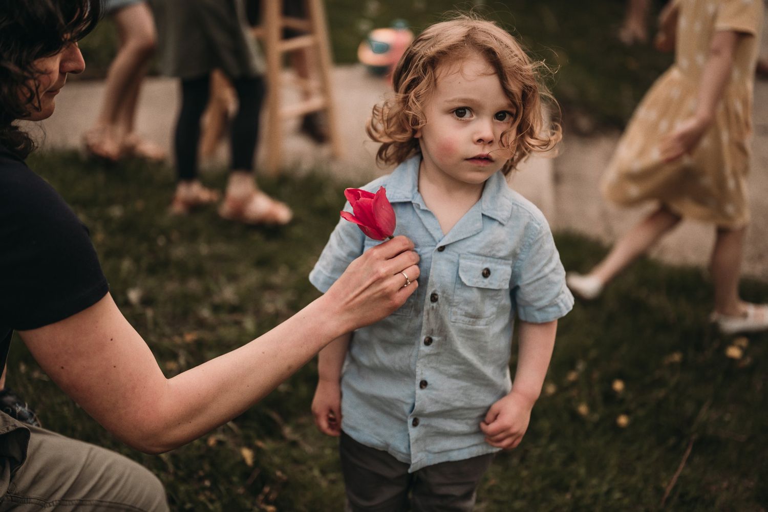 A candid moment of someone holding a colorful toy while interacting with a child wearing denim.