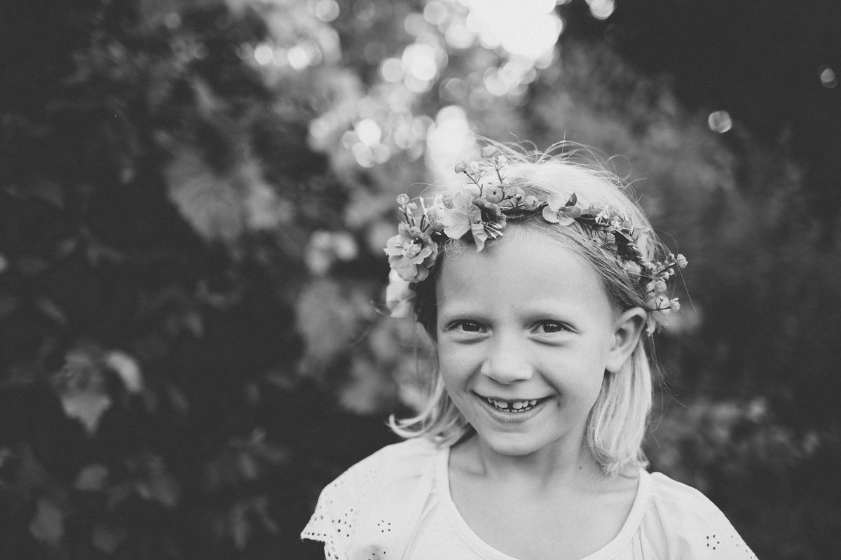 A black and white portrait showing someone wearing a delicate floral crown.