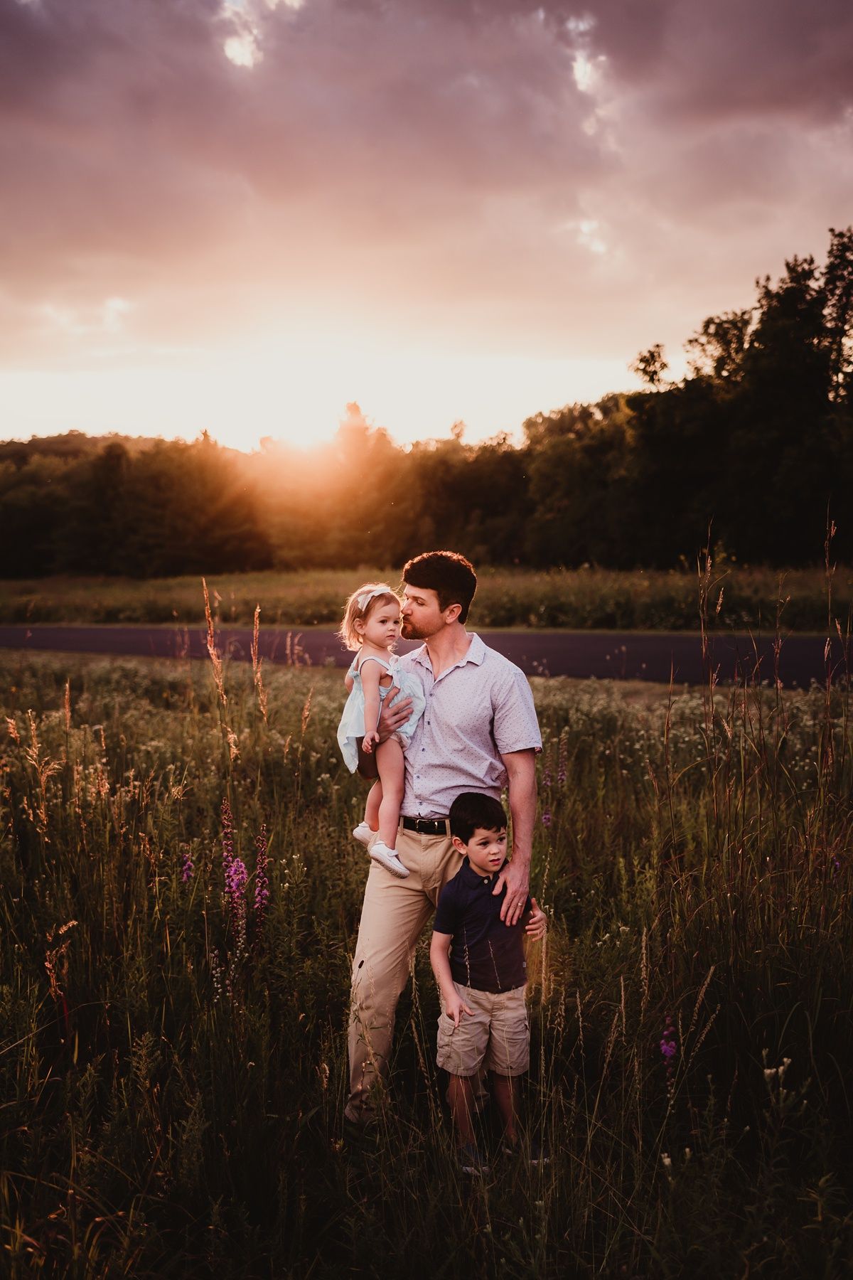 Family portrait in a wildflower meadow during magical golden hour sunset.