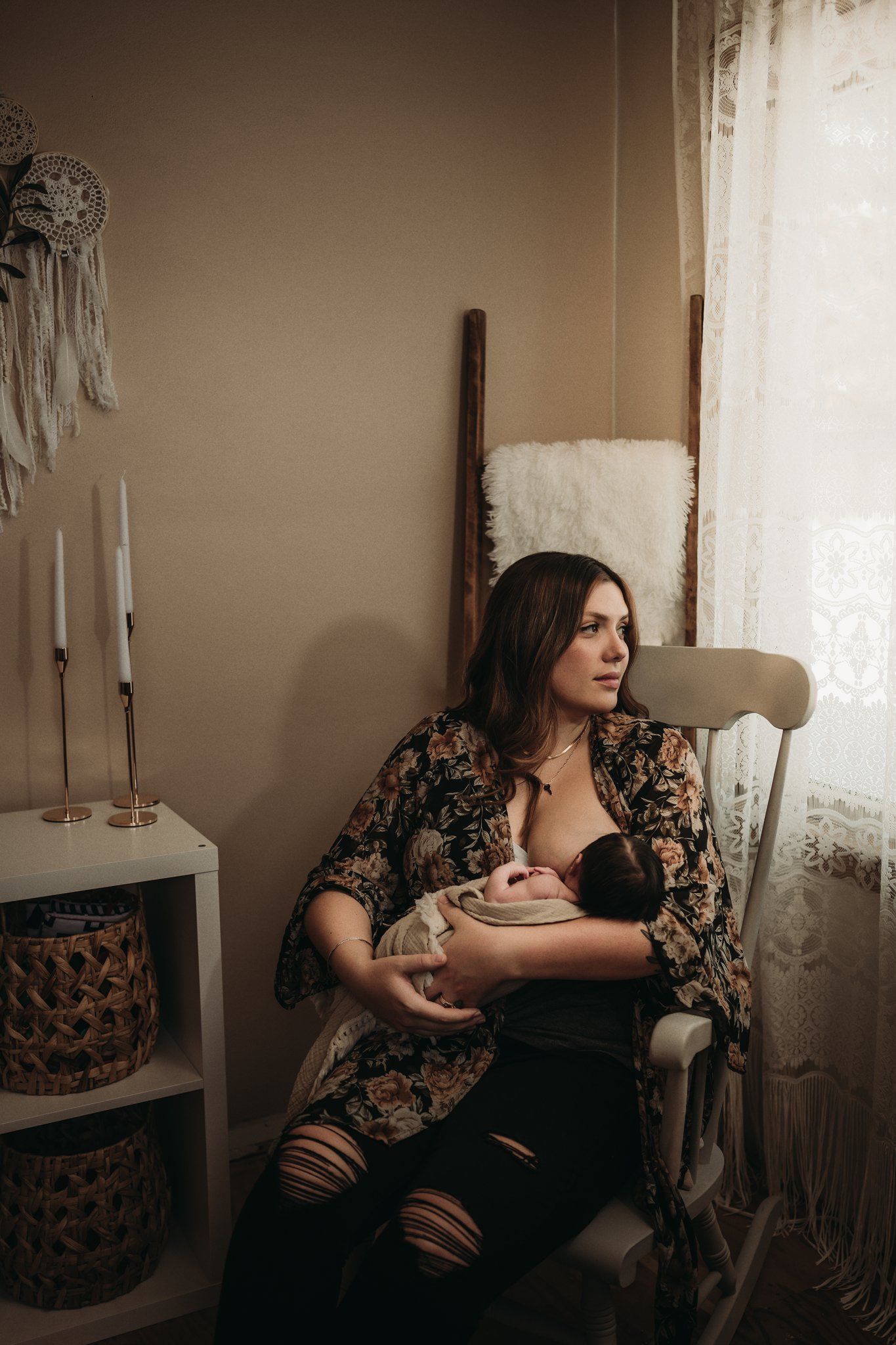 A cozy nursery scene with macrame wall decor and rocking chair near lace curtained window.