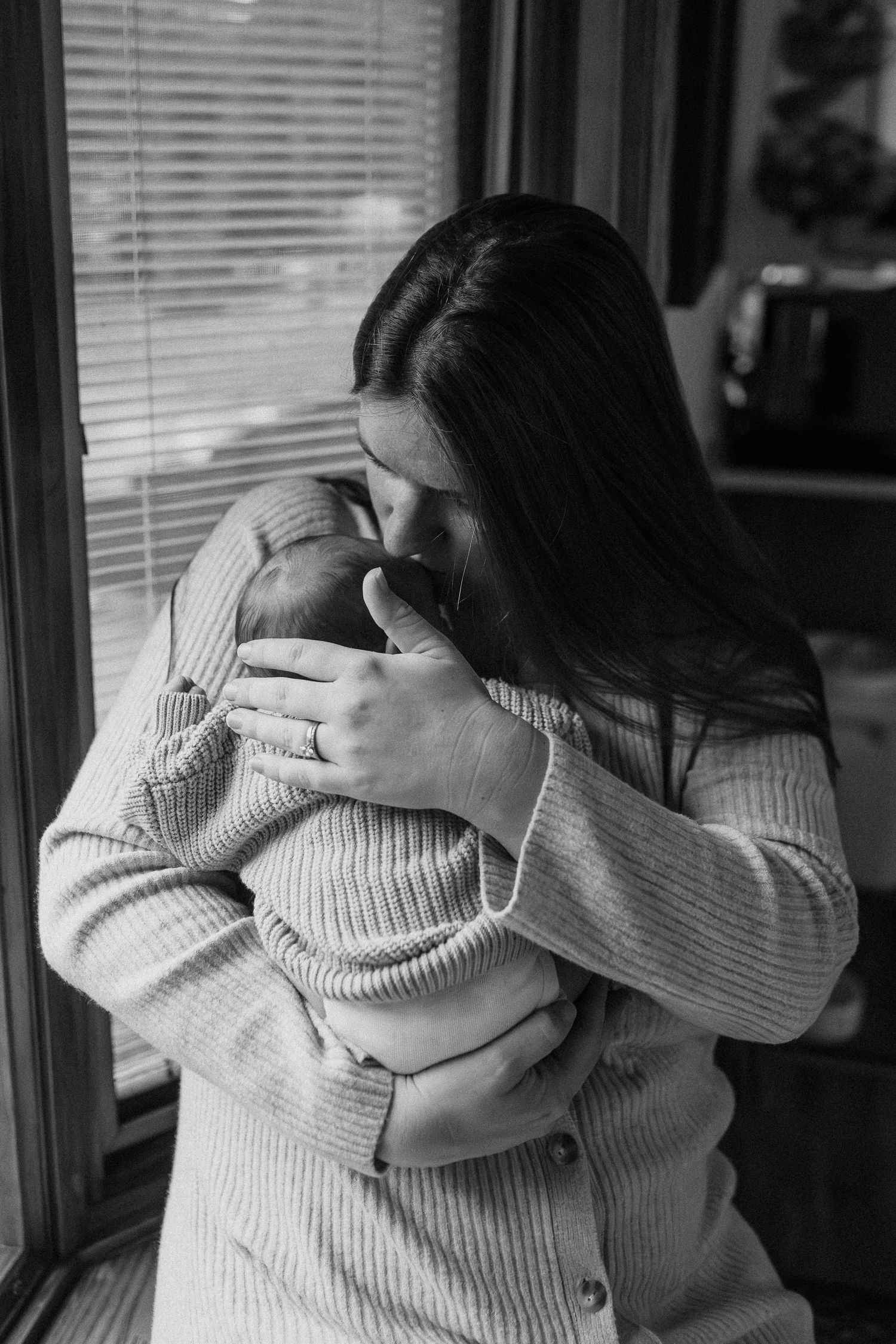 Intimate black and white photos showing tender embraces between parent and baby.