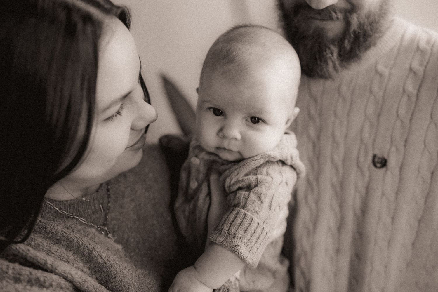 Black and white photo collage showing tender moments between parent and baby in intimate close-up shots.