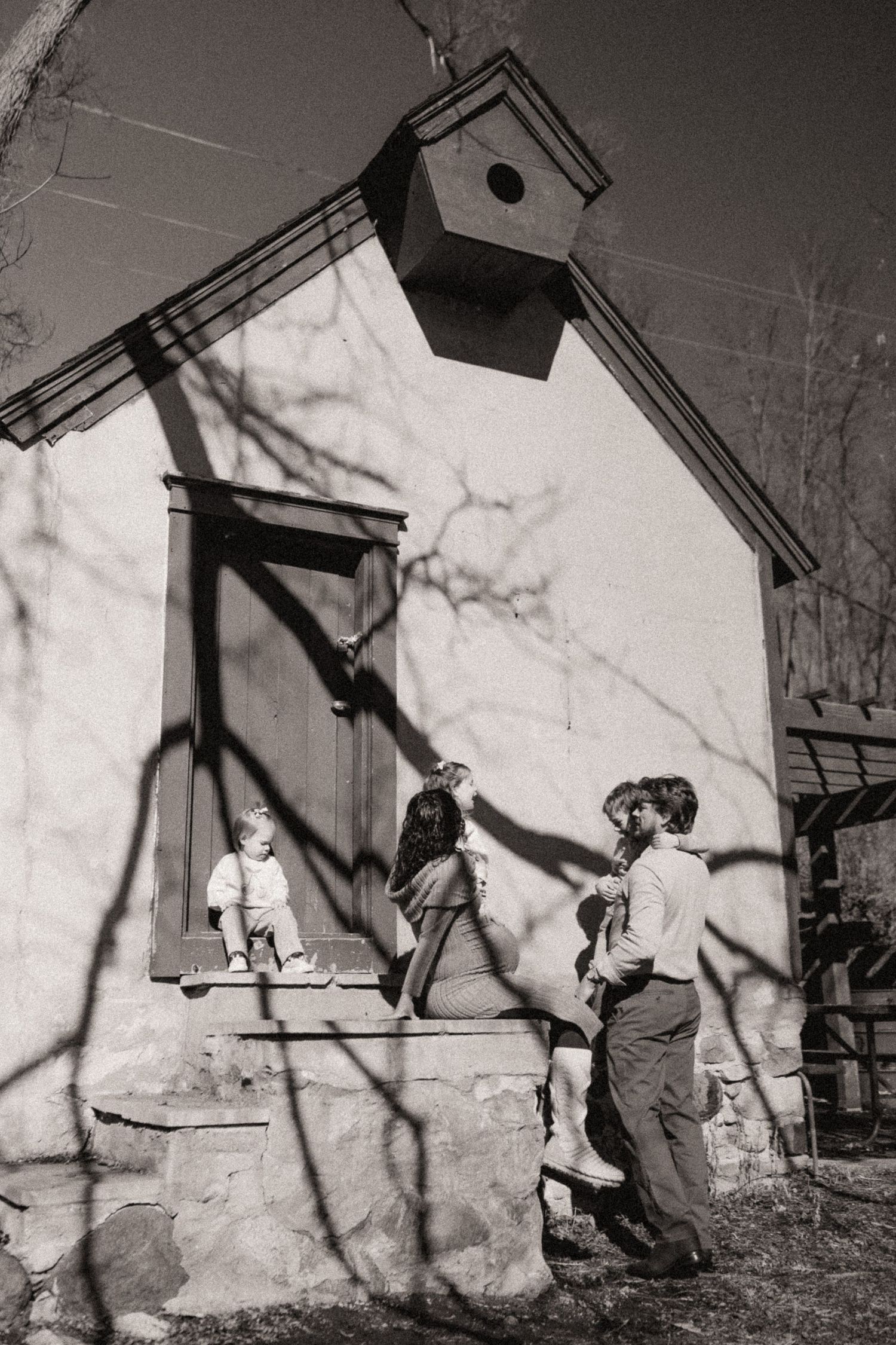 Vintage black and white photos of people interacting near a white birdhouse on a sunny day.