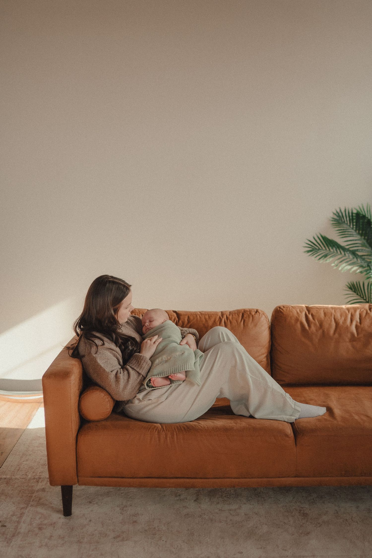 Relaxed lifestyle photos on a cognac leather couch with soft natural lighting through windows.