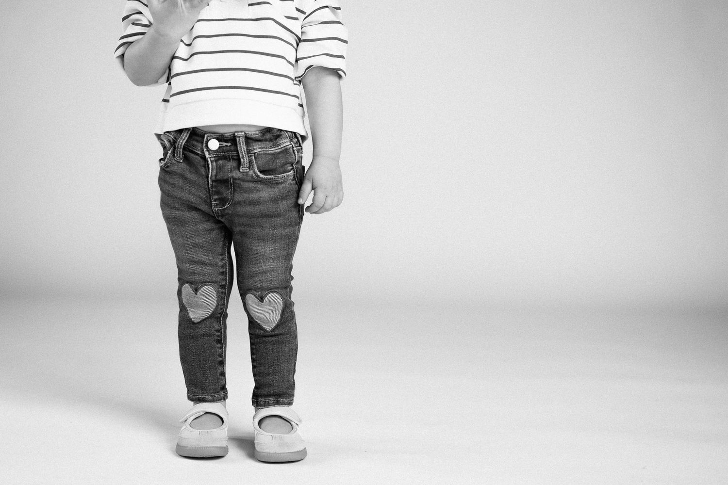 Black and white photo series showing different views of jeans with heart-shaped pockets and striped shirt details.