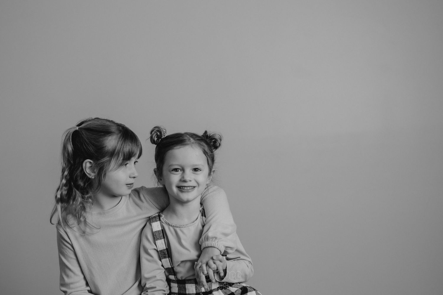 Black and white image of two people sharing a joyful moment together.