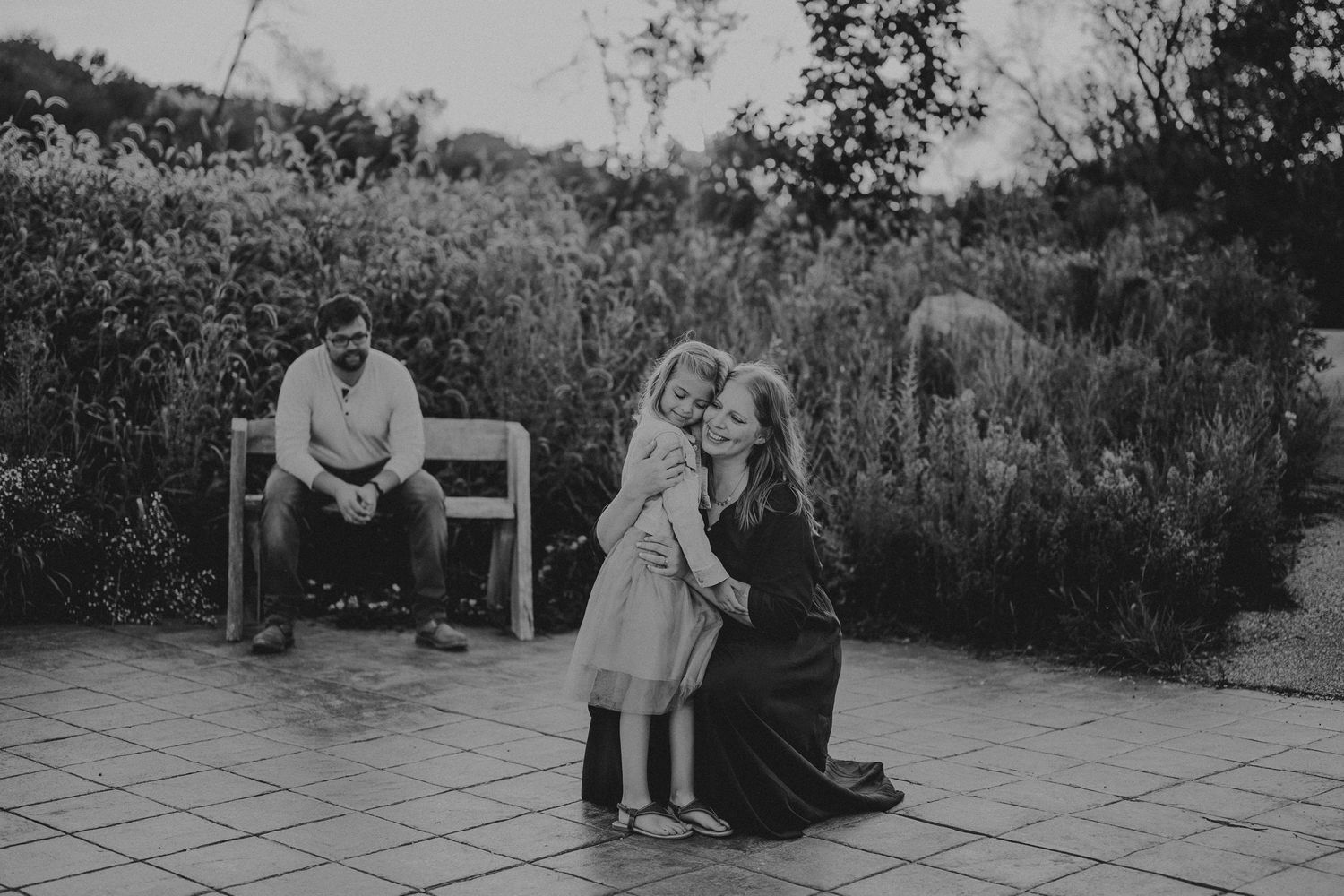 A black and white image showing people sharing a moment on an outdoor patio.