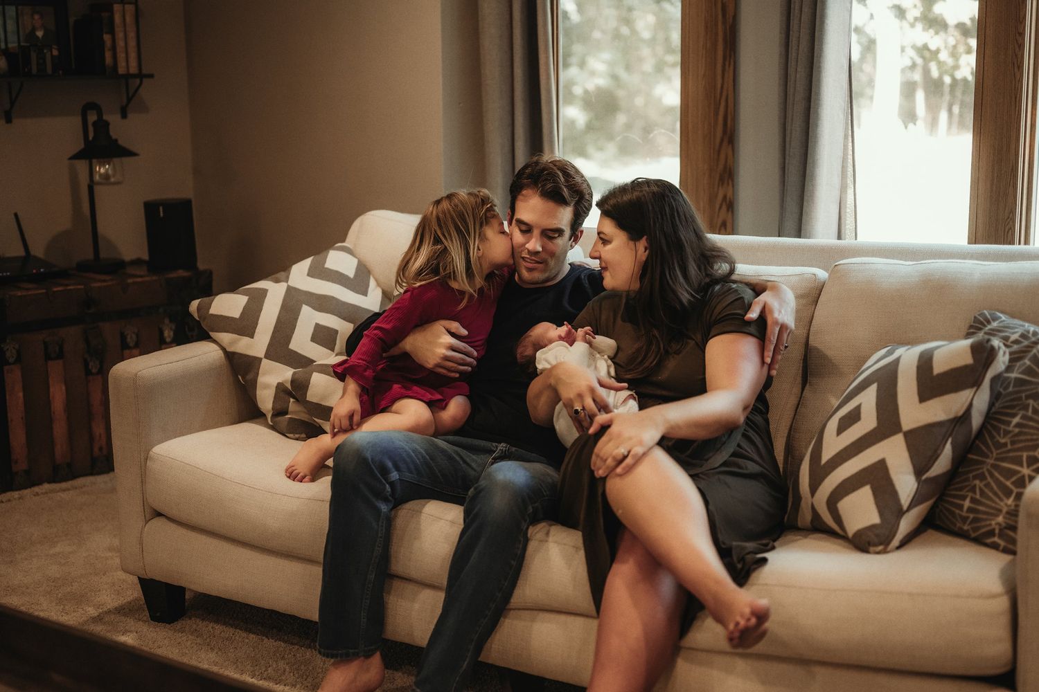 Family enjoying quality time together while relaxing on a comfortable living room sofa.