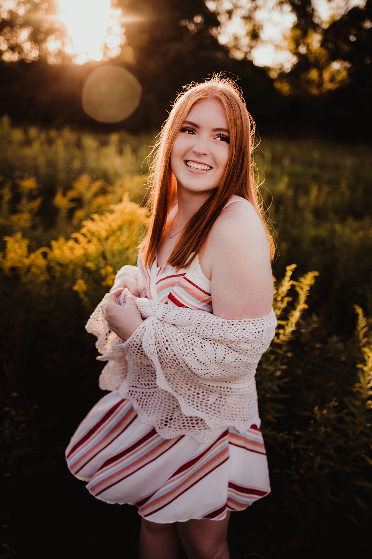 A sunset portrait in a field with warm golden light and flowing summer dress.