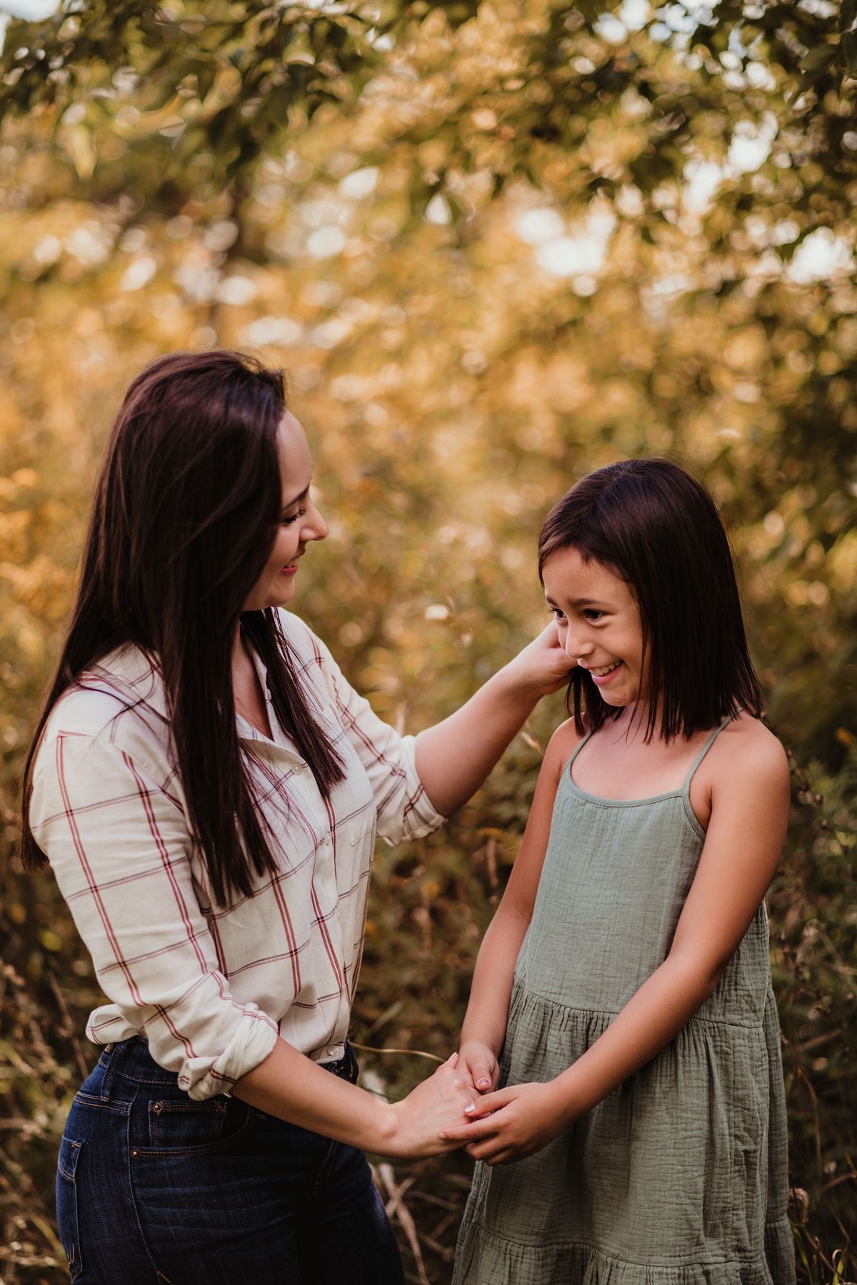 Candid outdoor family portrait showing joyful connection during golden hour.