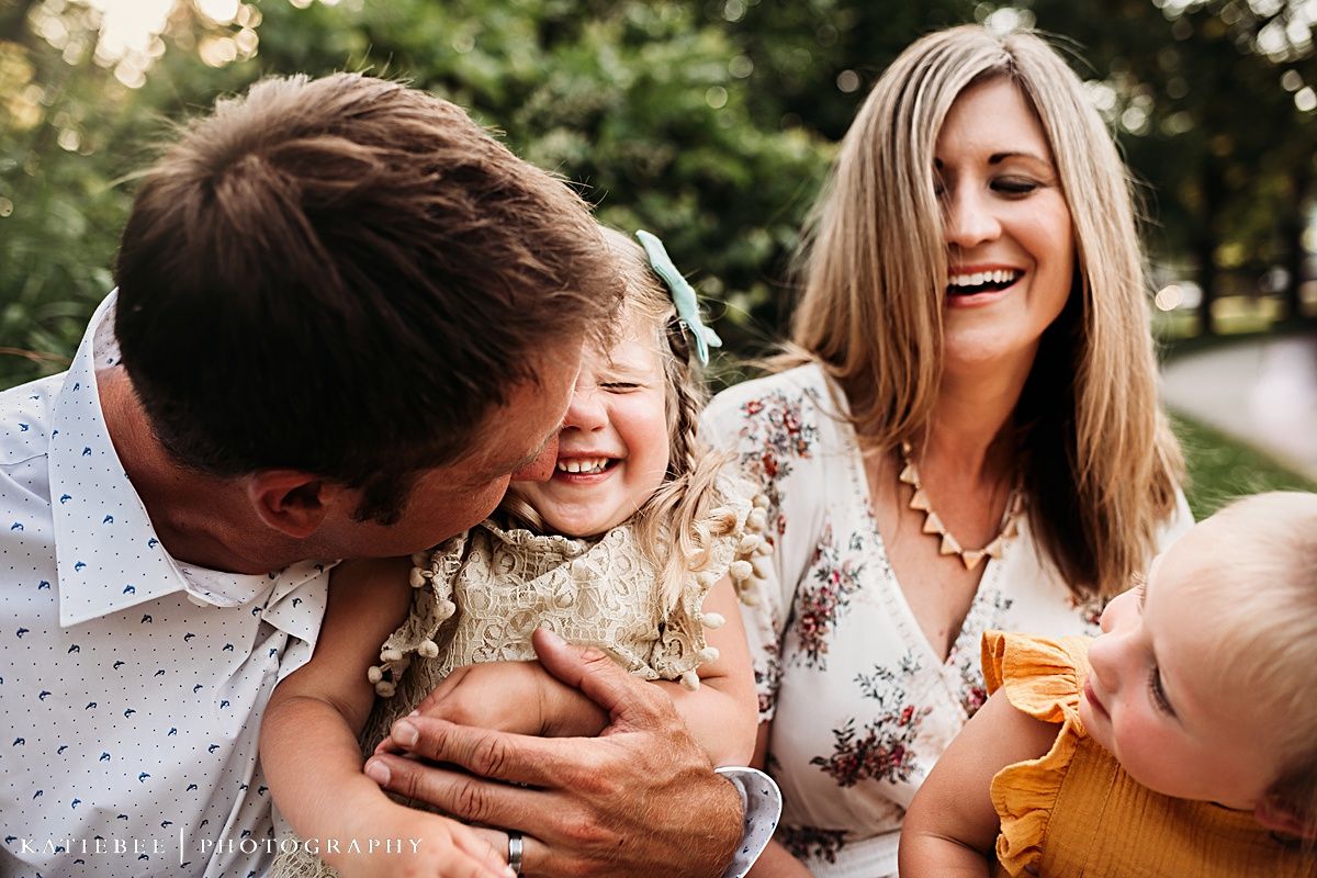 Candid family moment outdoors with floral and polka dot clothing during sunset.