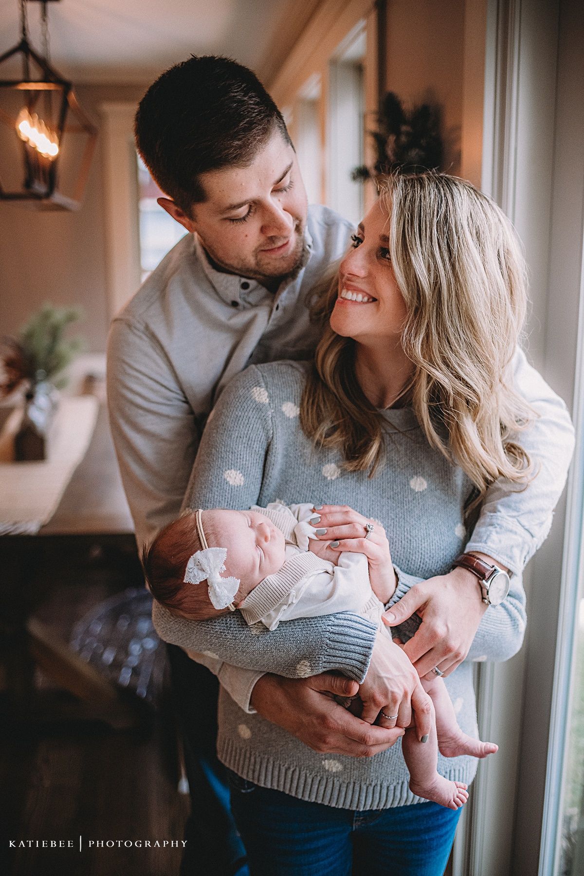 Intimate family portrait with natural window light in a cozy home setting.