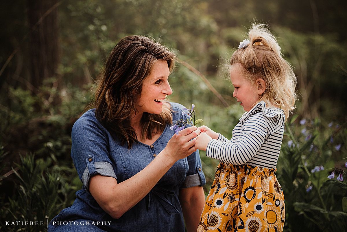 Two people share a playful and joyful moment together outdoors surrounded by wildflowers.