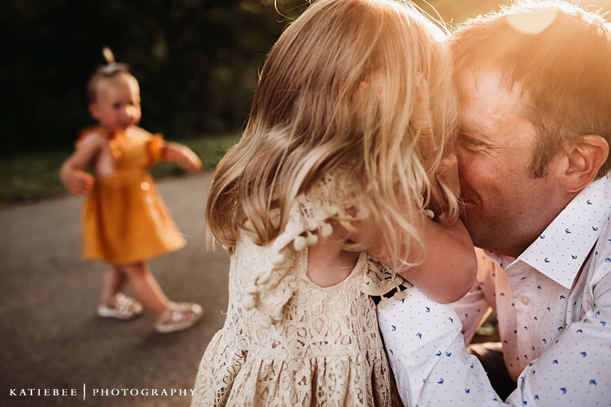 Intimate family moment captured during sunset with golden backlighting.