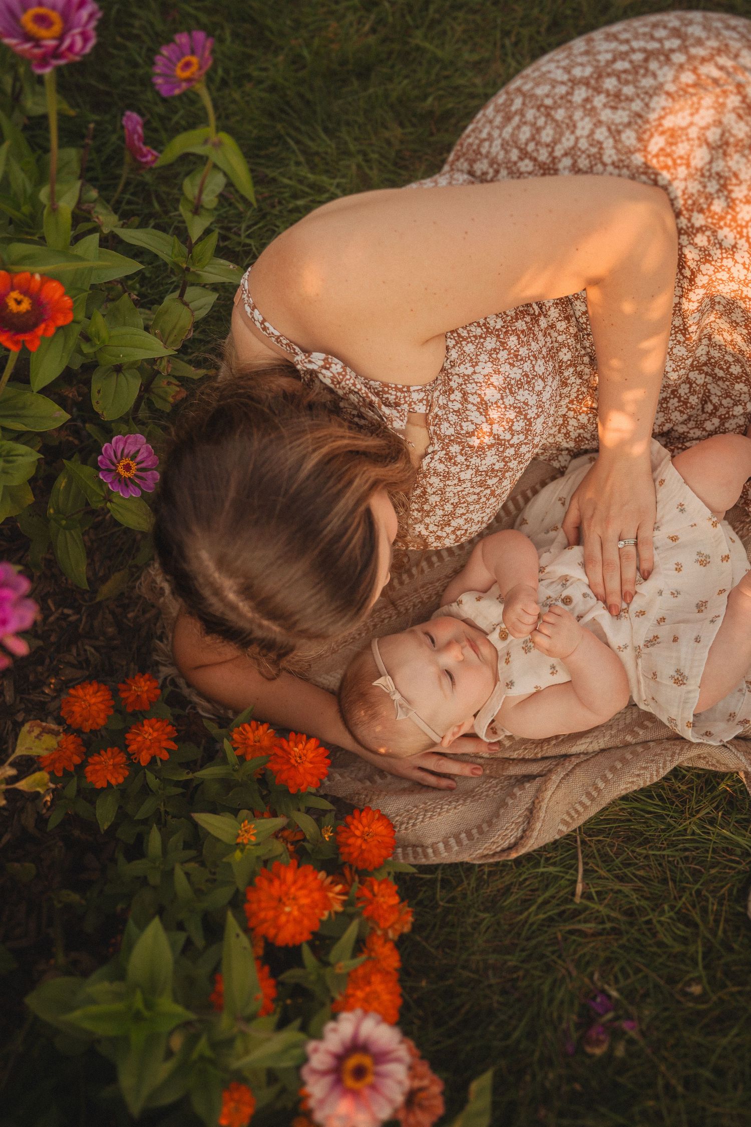 Tender moment captured from above in garden with colorful zinnias and orange flowers.