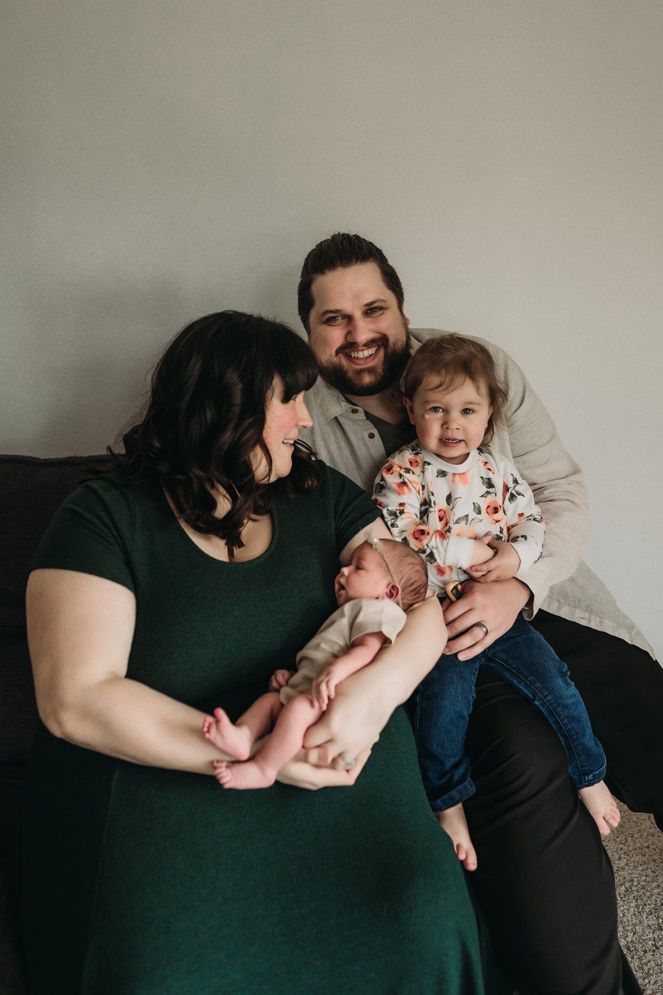 Intimate family portrait on couch with newborn baby and toddler.