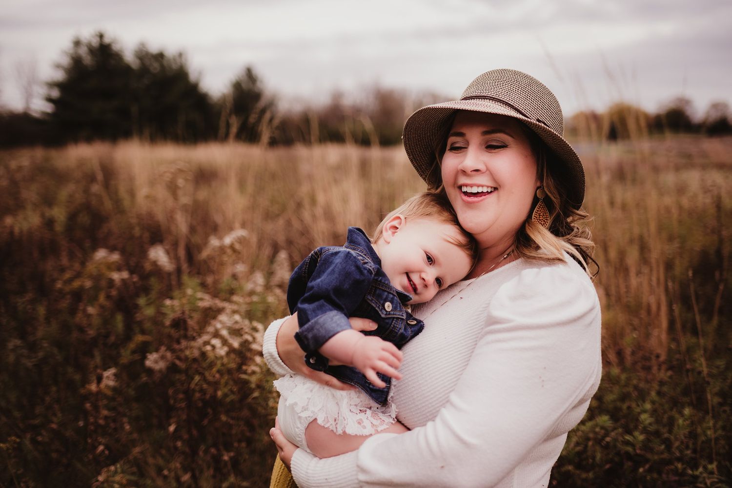 An affectionate outdoor portrait in a rustic field setting during autumn.