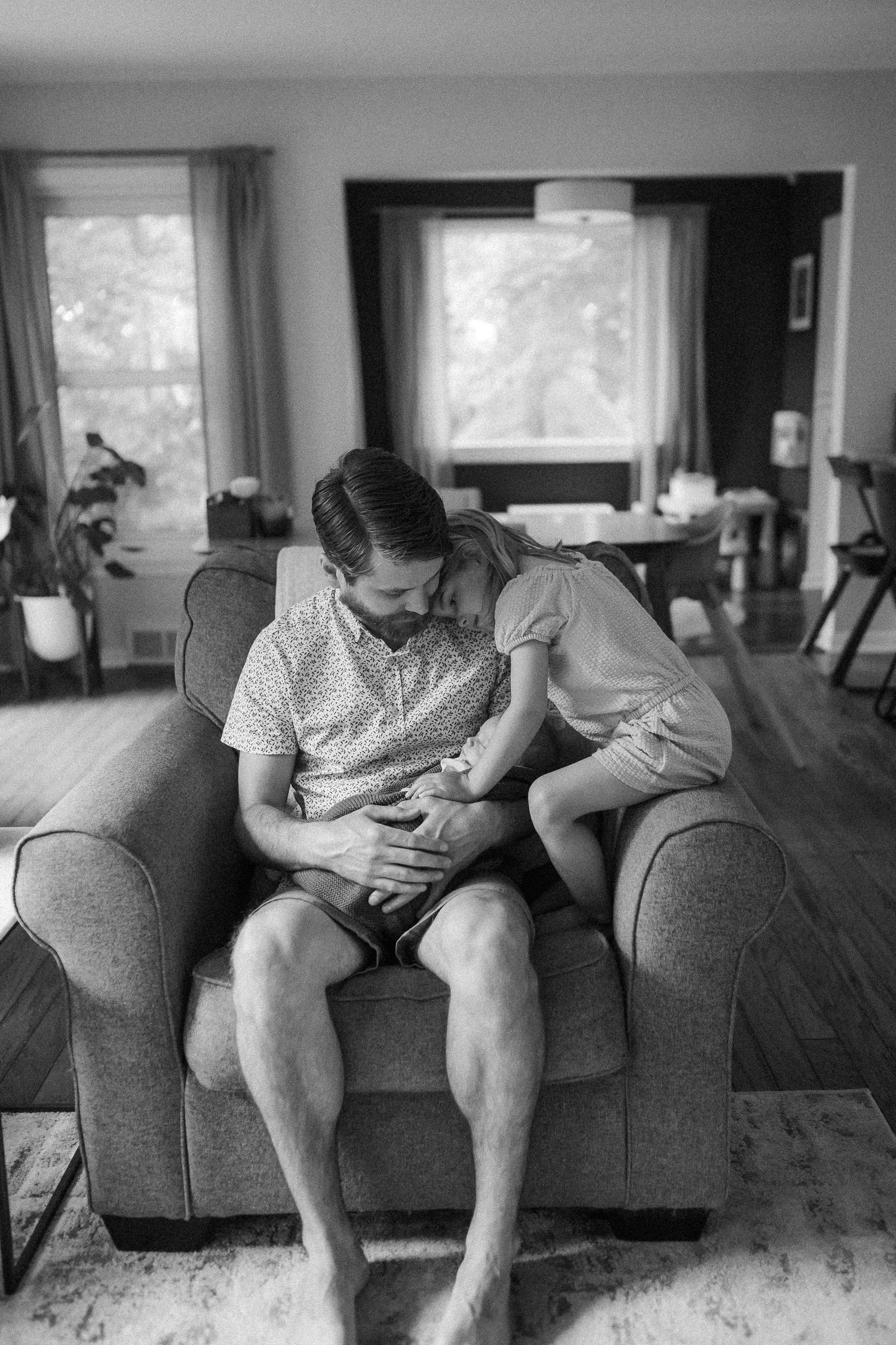 A series of intimate black and white photographs showing a cozy living room scene on a gray couch.