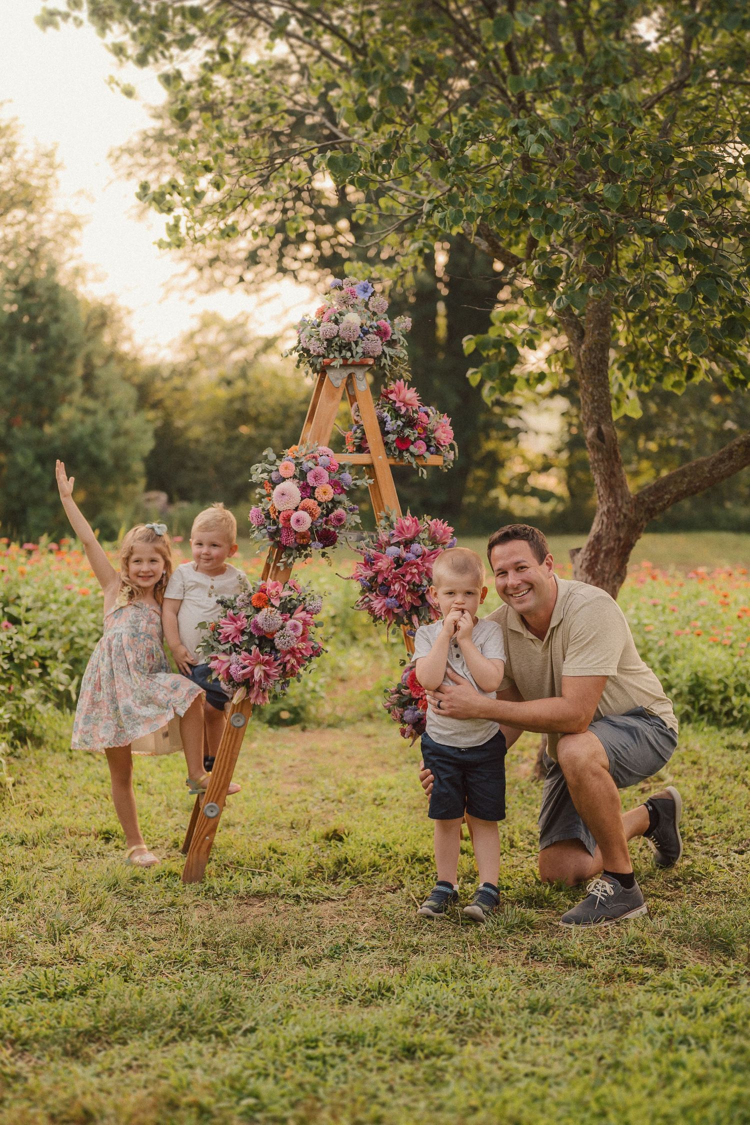 Family enjoying quality time together outdoors near flowering trees at golden hour.