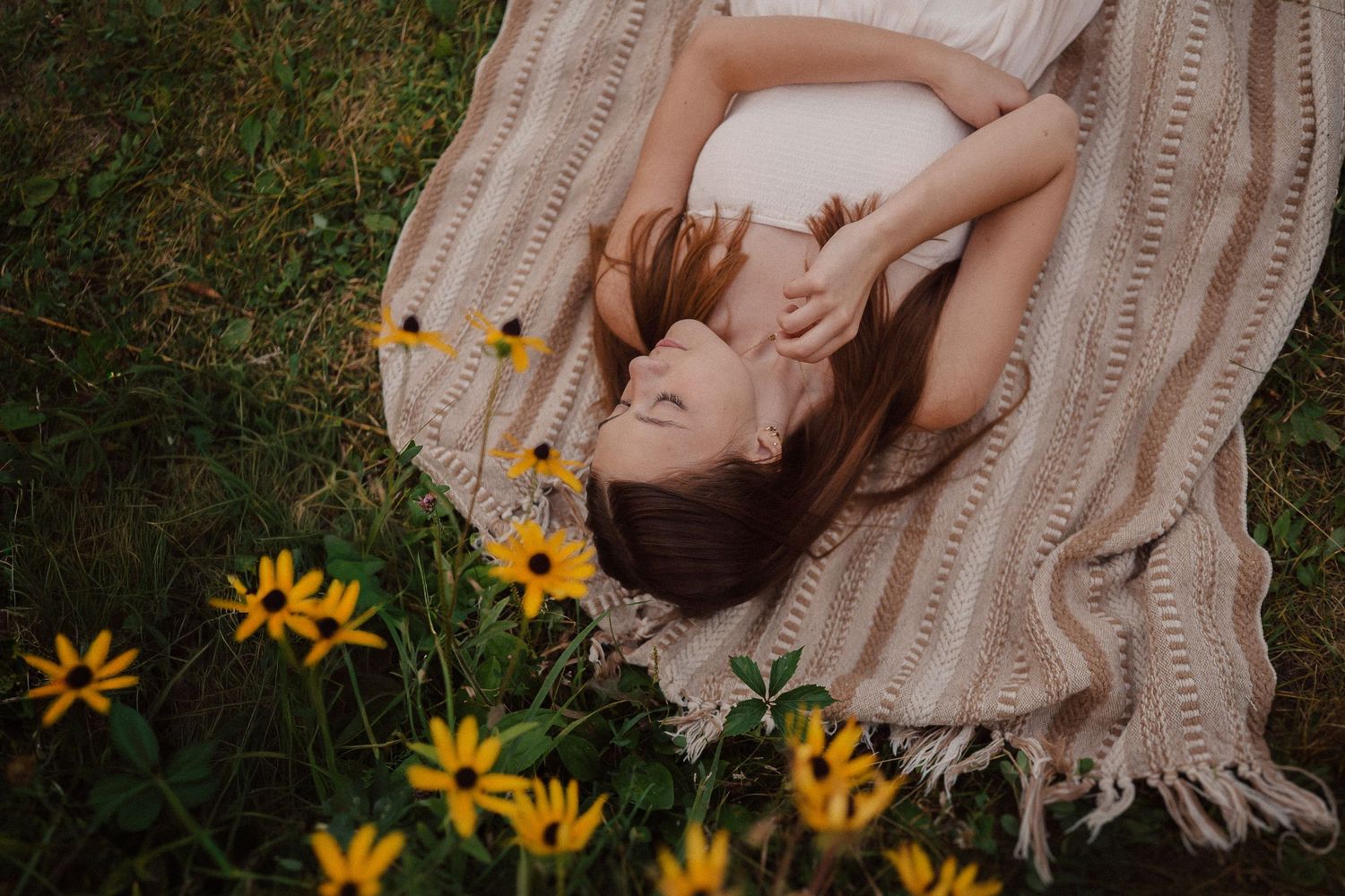 A serene summer portrait among blooming yellow wildflowers at sunset.