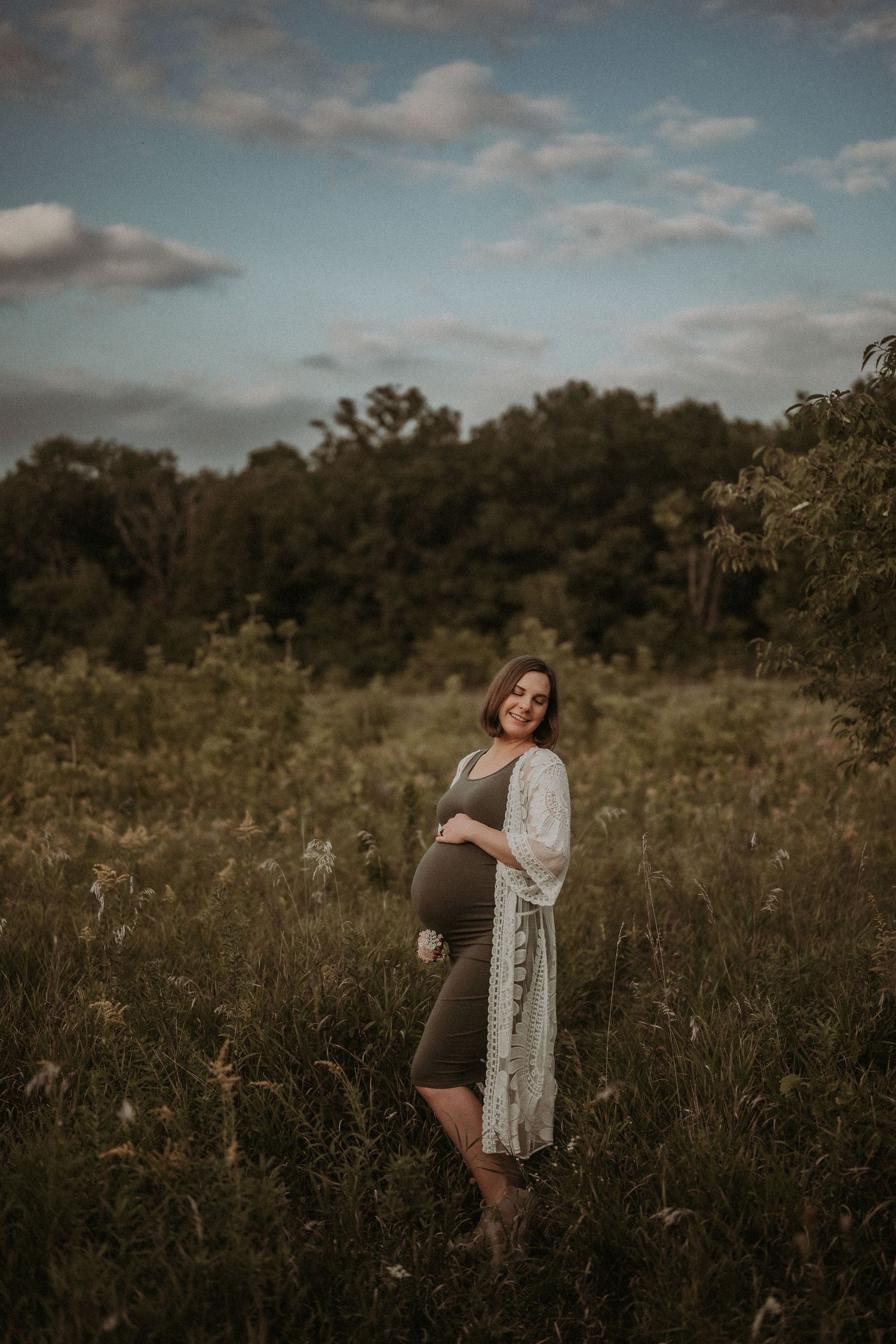 A maternity portrait in a wildflower field at golden hour.