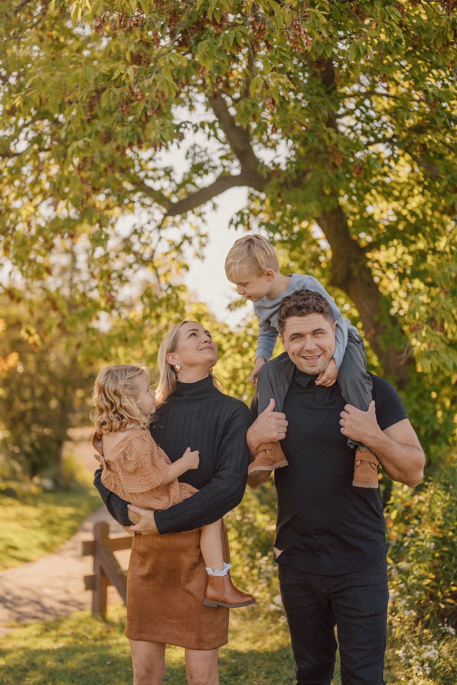 A series of candid family moments captured in warm autumn sunlight with trees and foliage in the background.
