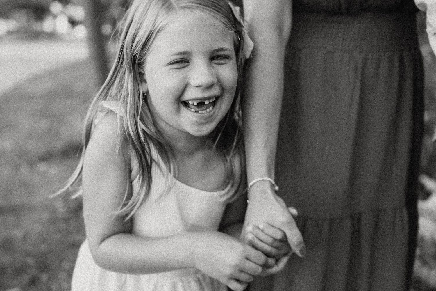A close-up black and white photo captures a joyful moment of genuine laughter.