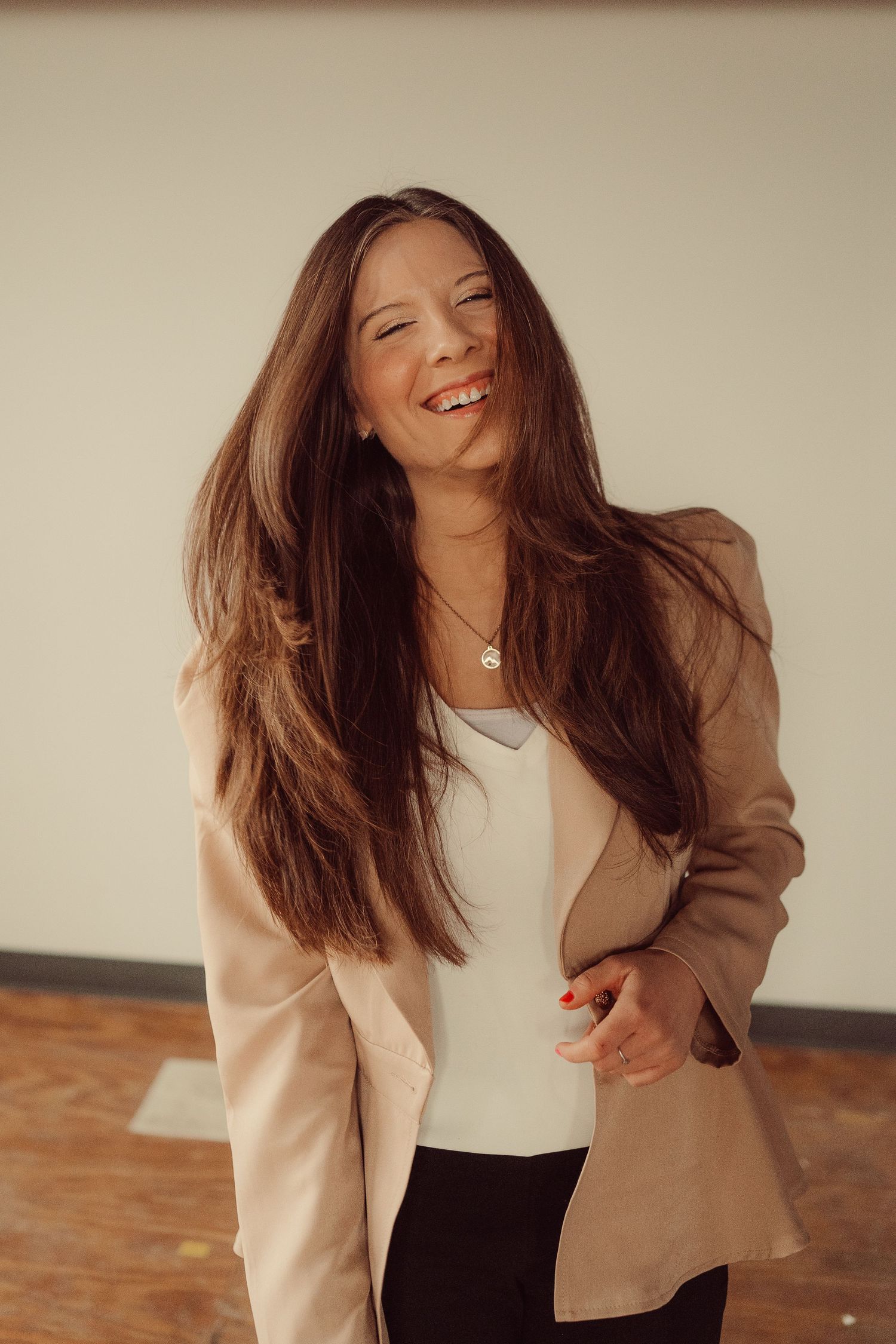 Candid moment captured showing joyful expression and long hair with casual business attire.