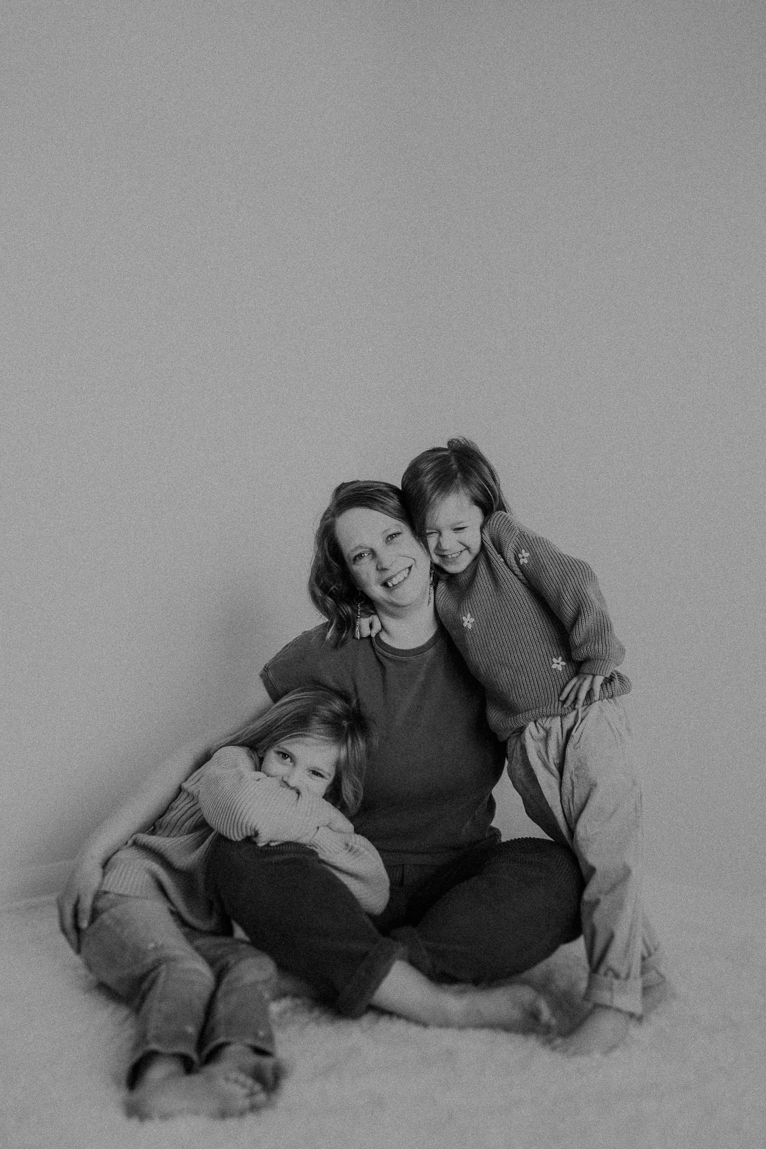 Black and white studio photograph showing loving interaction and laughter.