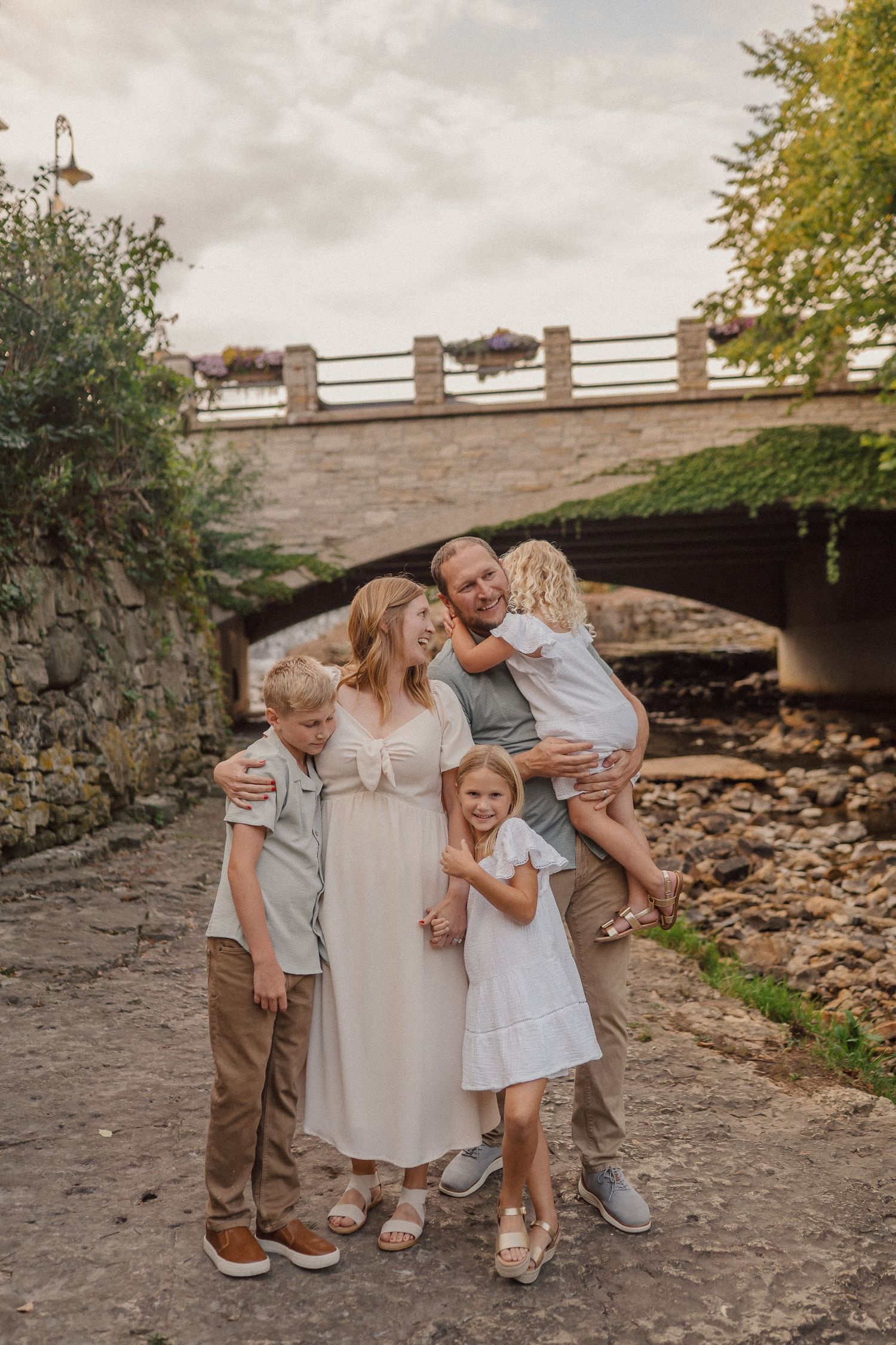 A joyful family moment captured under a stone bridge.
