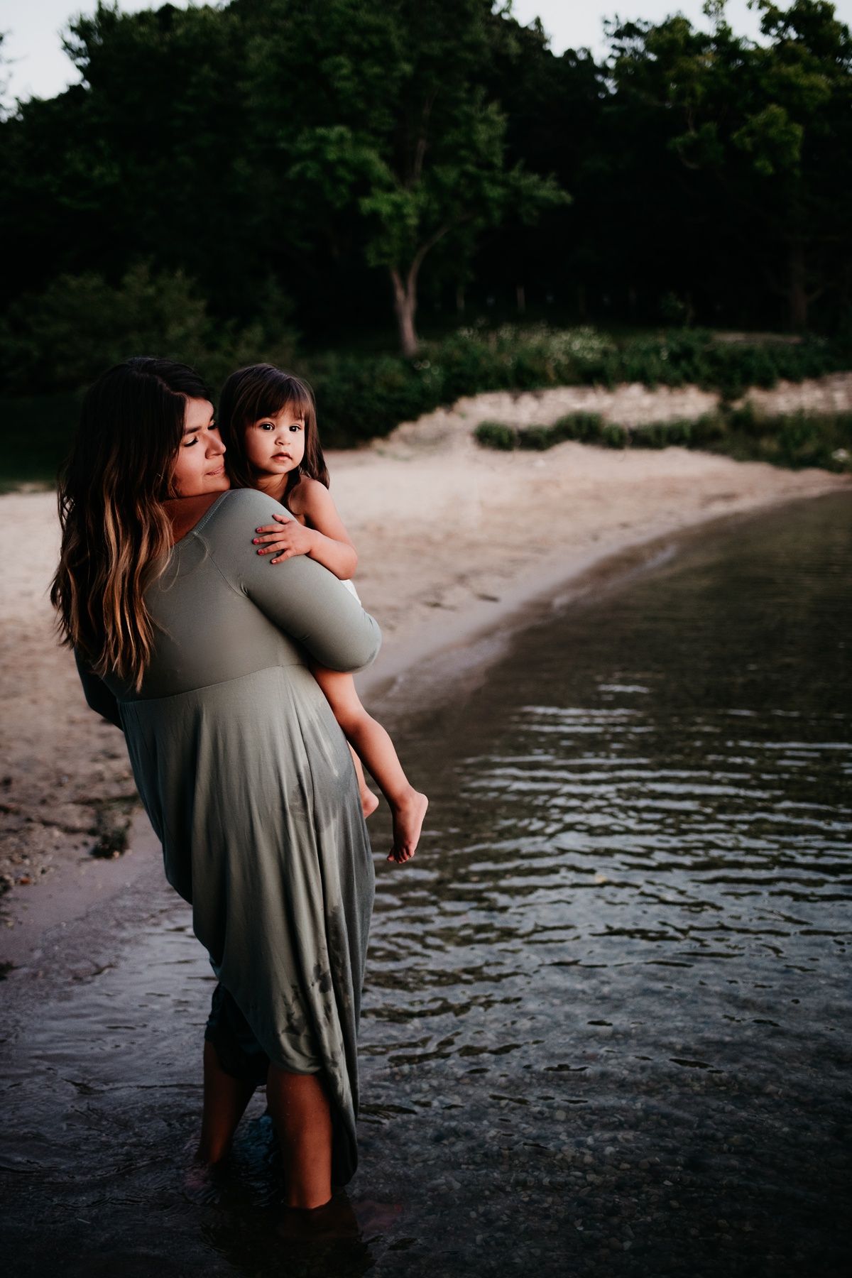 A gentle scene at the water's edge with grey dress against a serene beach backdrop.