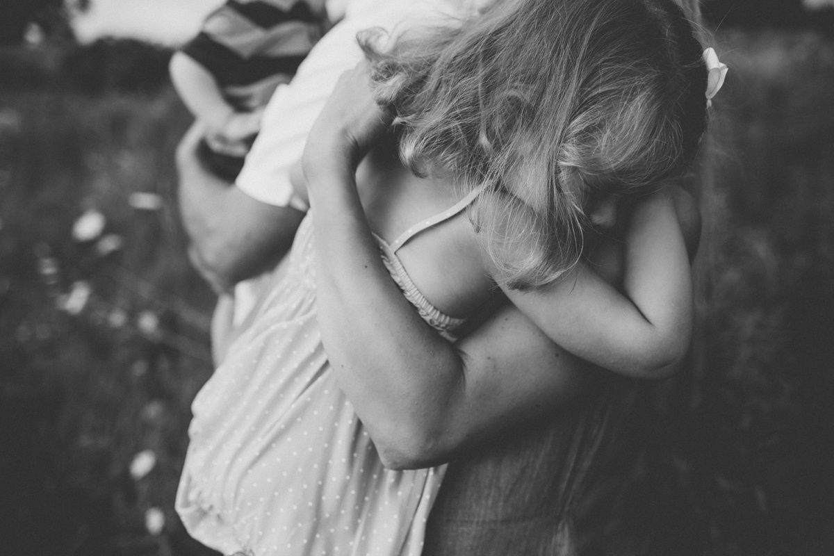 Black and white intimate moment captured during outdoor family photoshoot.