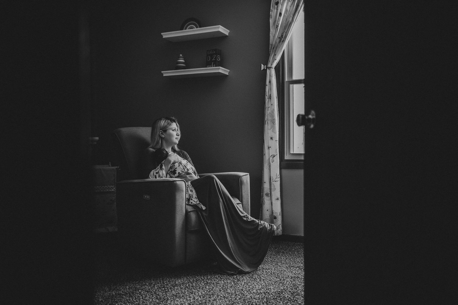 Artistic black and white photo showing a quiet moment in corner room with window light.