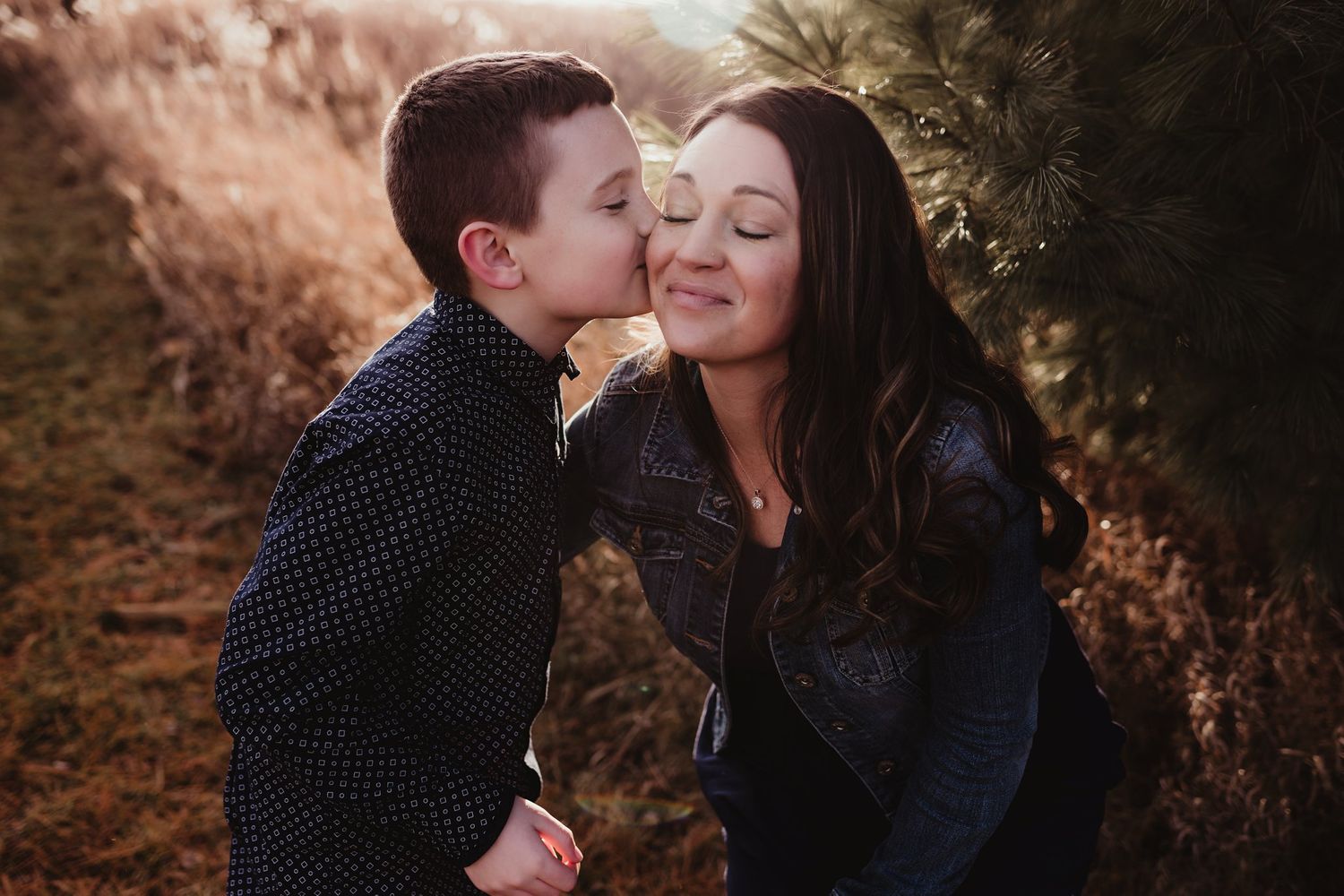 A sweet moment of affection shared between two people in an outdoor setting.