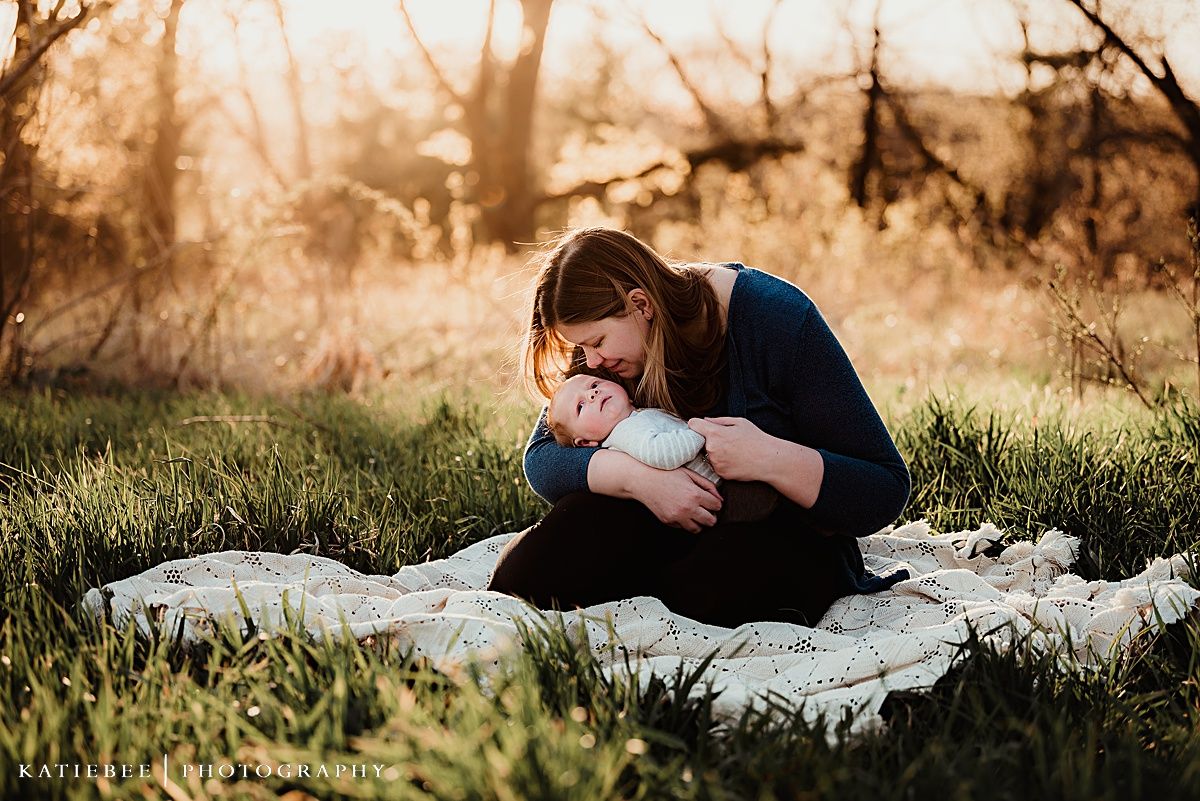 Candid lifestyle portrait of tender moment between parent and child on picnic blanket.