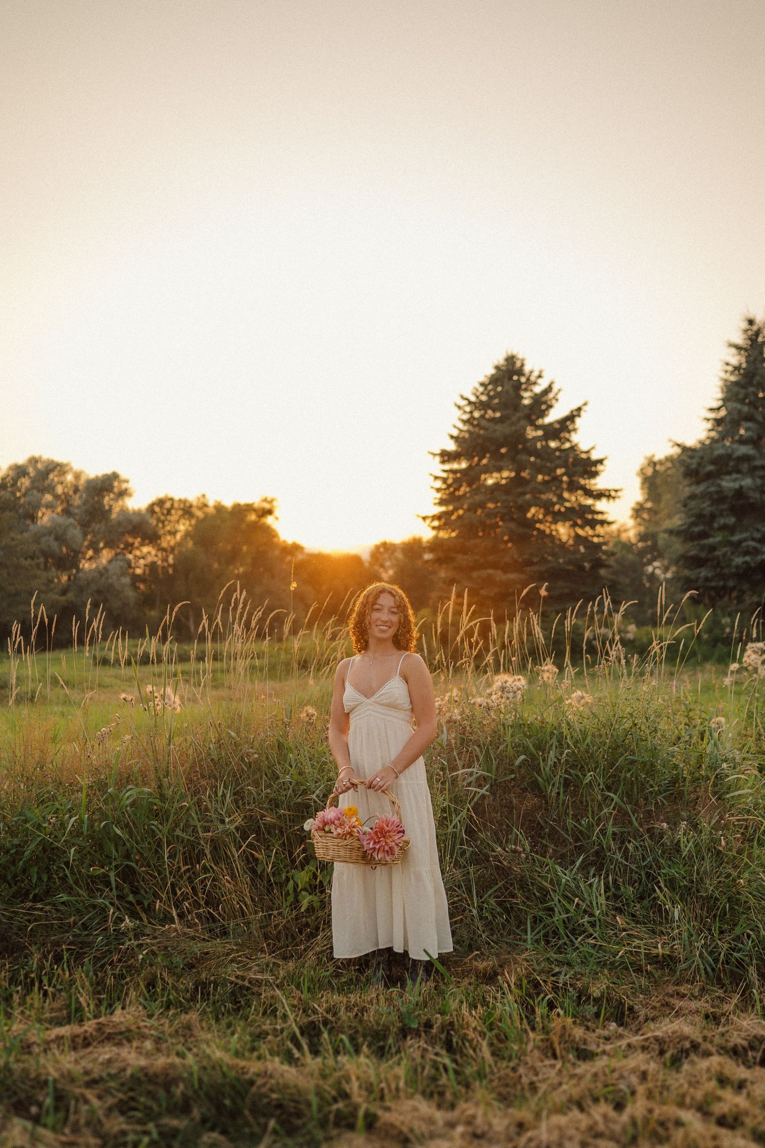 Dreamy sunset photoshoot in a wild meadow with tall grass and golden light.