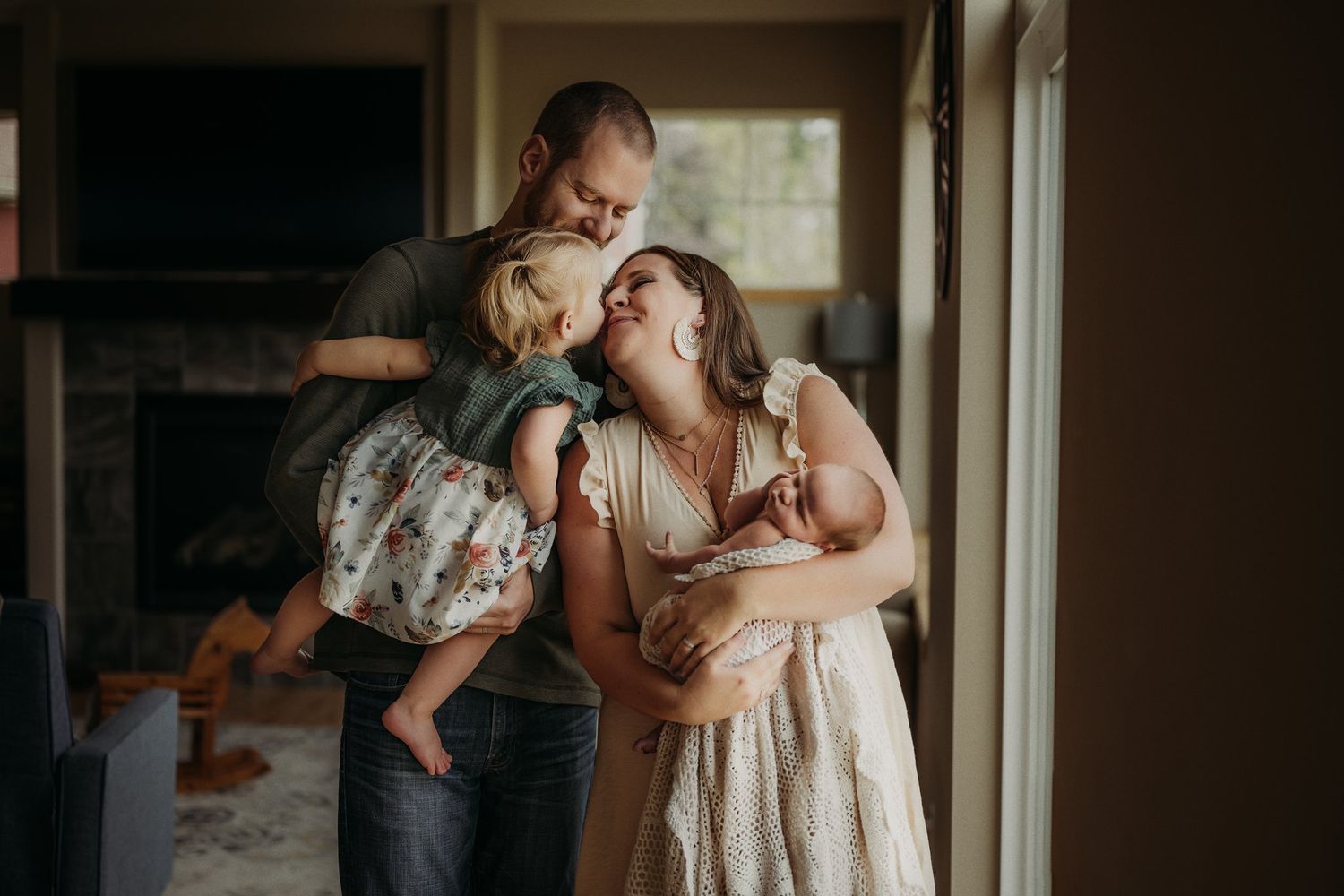 Candid family moment captured in living room as they share laughter near window.